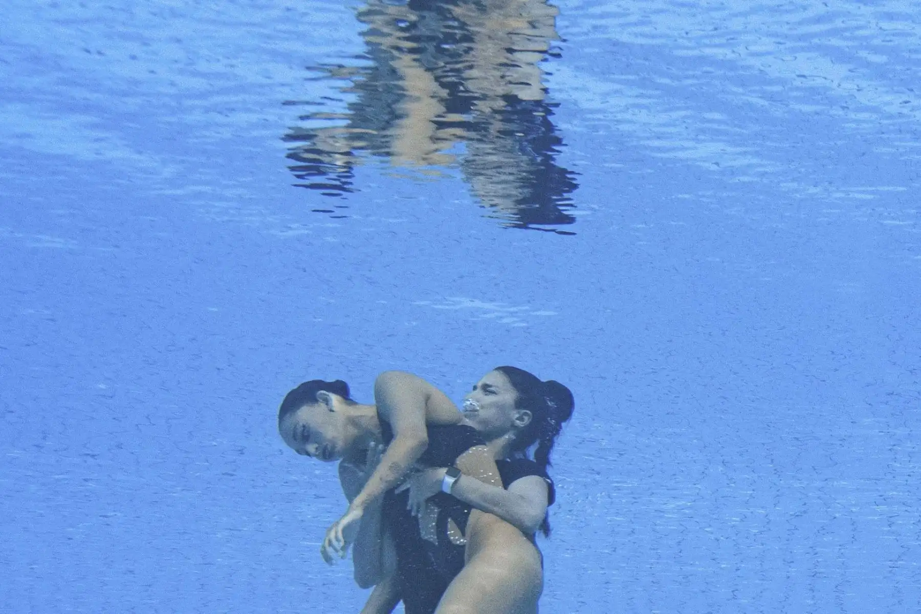 La entrenadora española, Andra Fuentes, nada para salvar a Anita Alvarez del fondo de la piscina durante un incidente en las finales de natación artística libre en solitario de mujeres, durante el Campeonato Mundial Acuático de Budapest 2022. Foto: AFP
