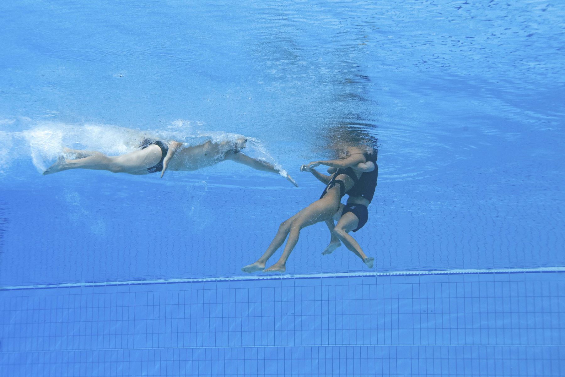 La entrenadora española, Andra Fuentes, nada para salvar a Anita Alvarez del fondo de la piscina durante un incidente en las finales de natación artística libre en solitario de mujeres, durante el Campeonato Mundial Acuático de Budapest 2022. Foto: AFP