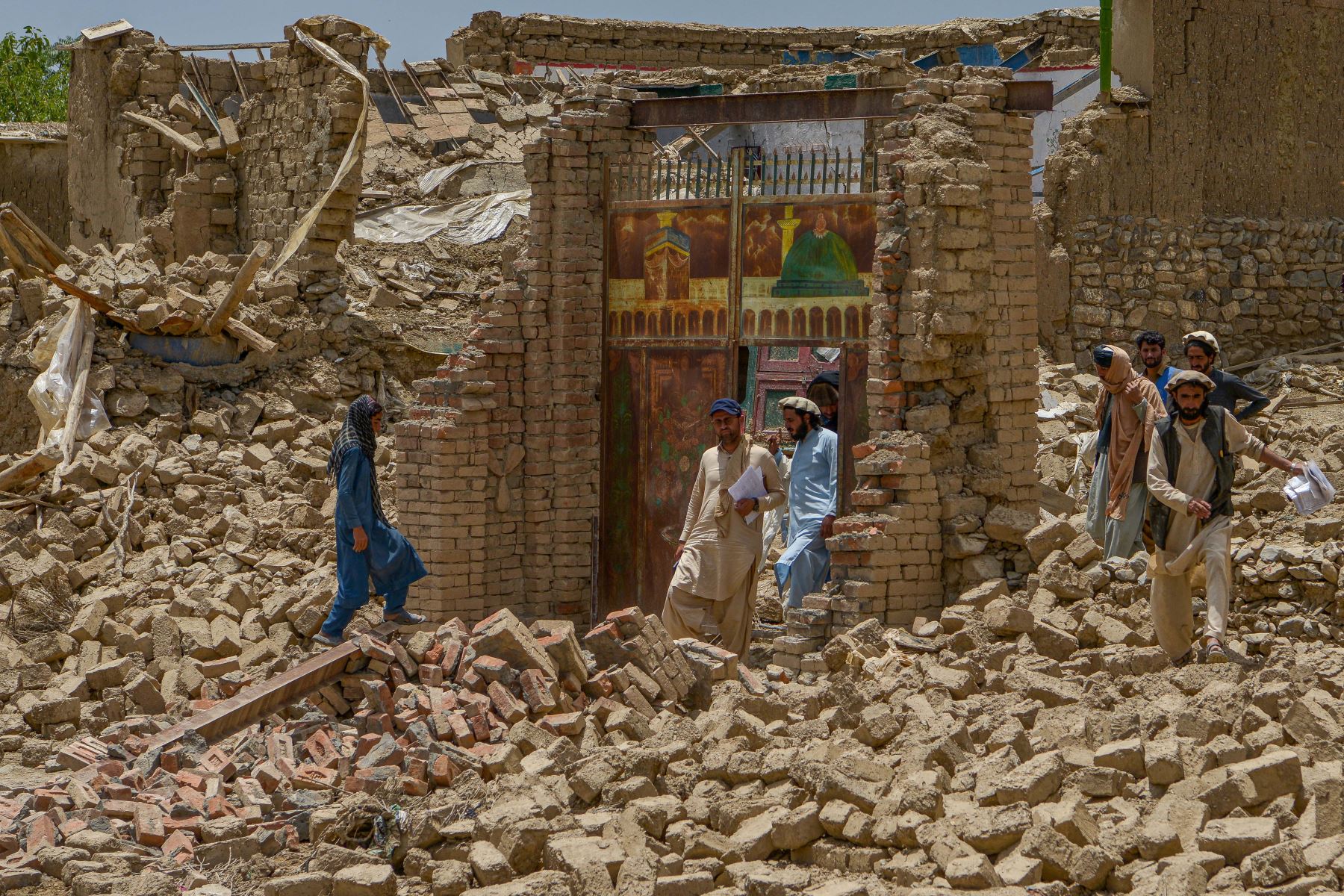 Hombres afganos buscan sus pertenencias entre las ruinas de una casa dañada por un terremoto en el distrito de Bernal, provincia de Paktika. Foto: AFP
