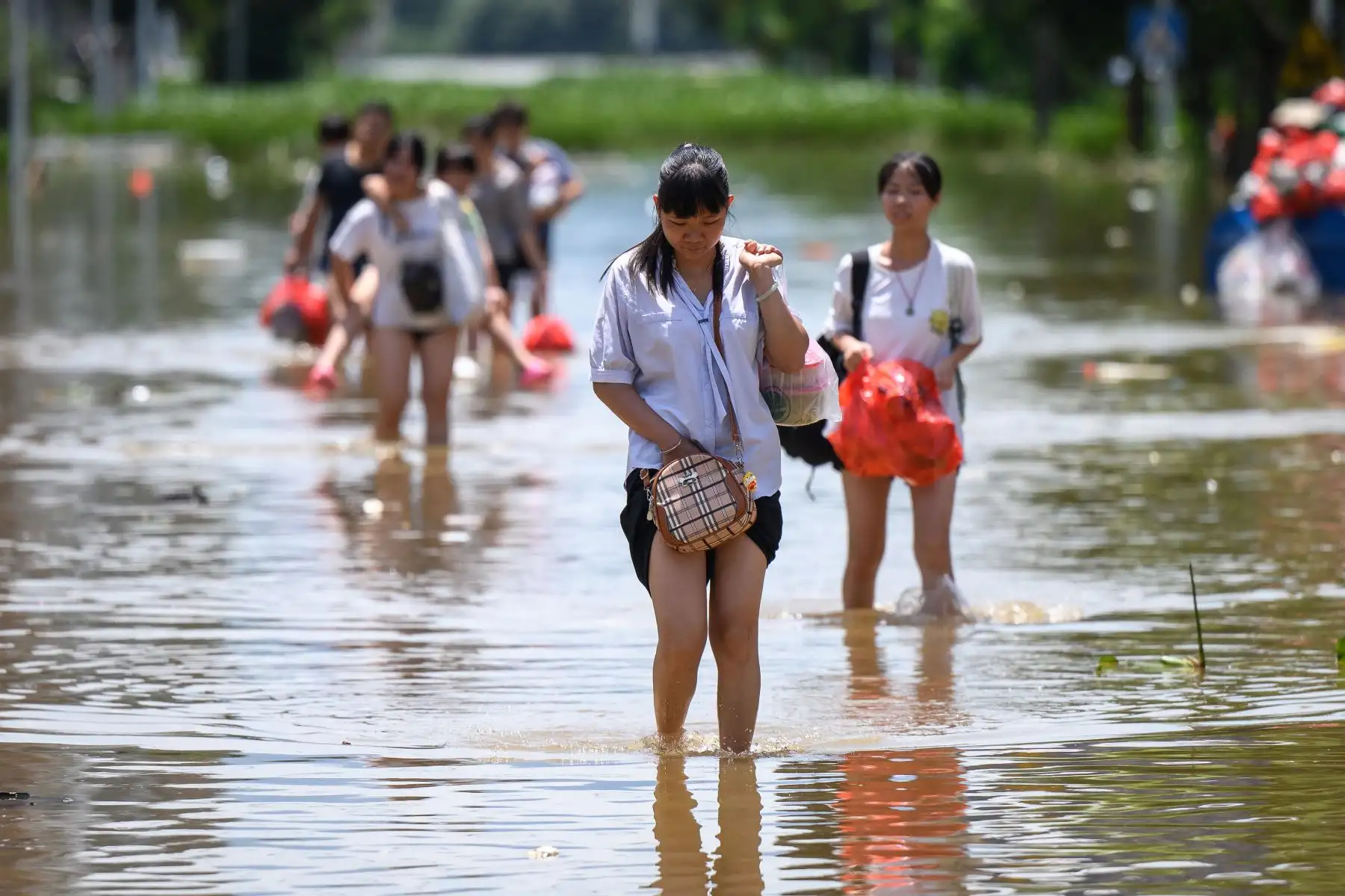 Residentes caminan por un área inundada después de las fuertes lluvias en Yingde, ciudad de Qingyuan, en la provincia sureña china de Guangdong. Foto: AFP