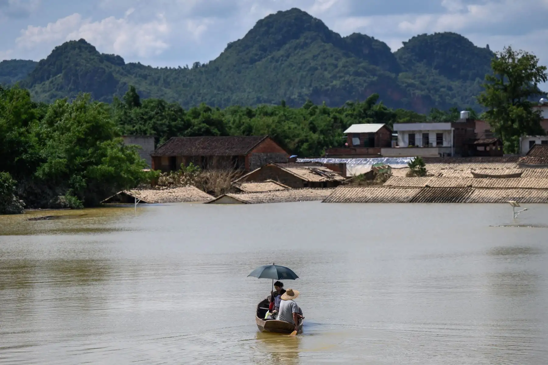 Residentes viajan en un bote en un área inundada después de las fuertes lluvias en Yingde, ciudad de Qingyuan, en la provincia de Guangdong, en el sur de China. Foto: AFP