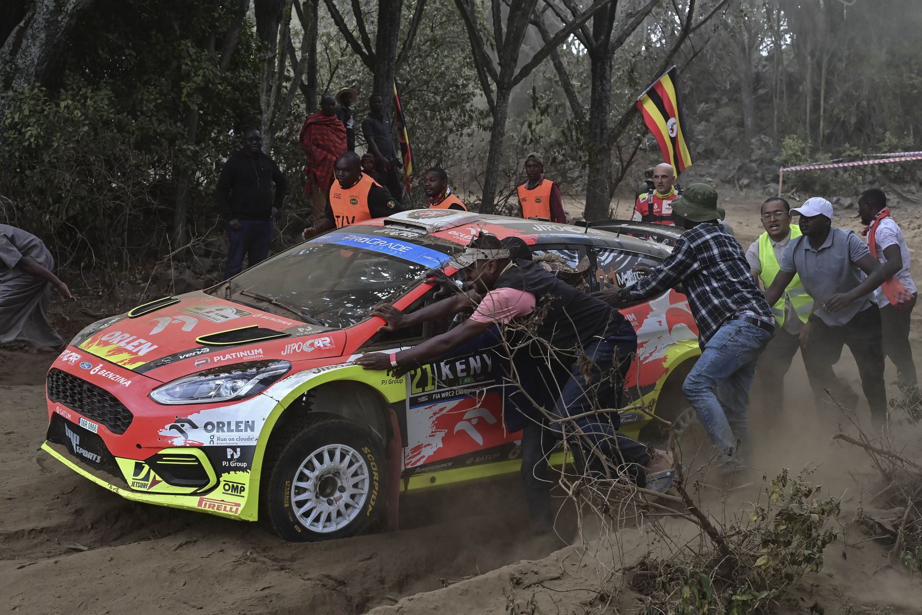 Los espectadores ayudan a sacar del curso al Ford Fiesta MkII del equipo de rally checo conducido por Martin Prokop y Zdenek Jurka, que se descompuso en medio del polvo durante la sección de Kedong del Safari Rally Kenya 2022. Foto: AFP