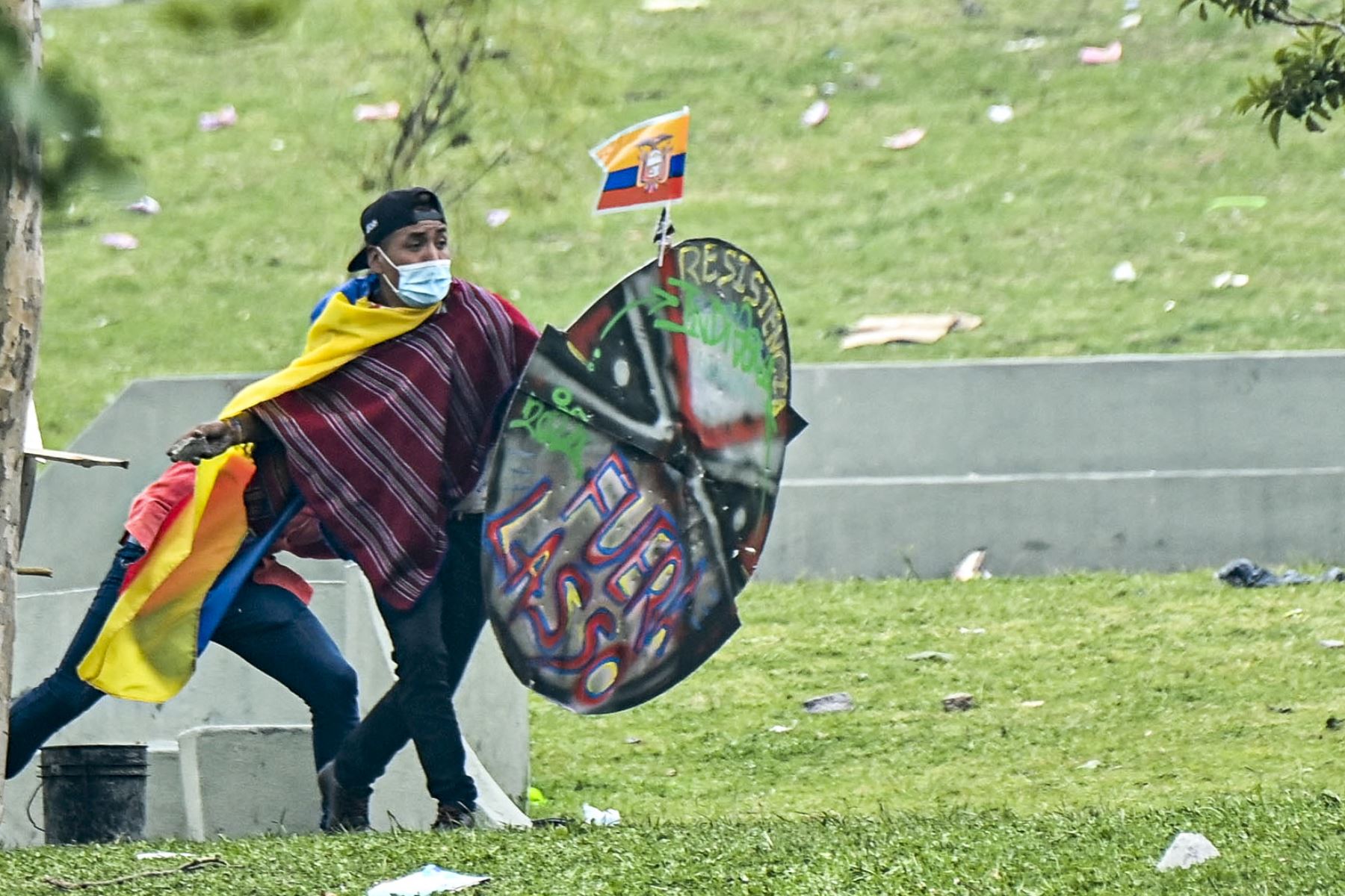 Un manifestante se protege con un escudo improvisado durante enfrentamientos con antidisturbios en el parque El Ejido, en Quito. AFP