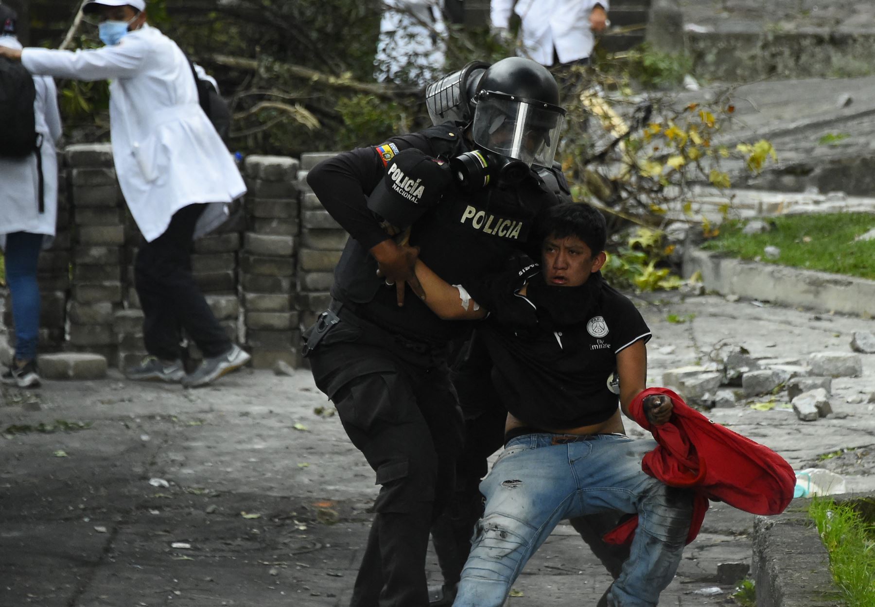 Un antidisturbios detiene a un manifestante durante enfrentamientos en el parque El Ejido, en Quito. AFP