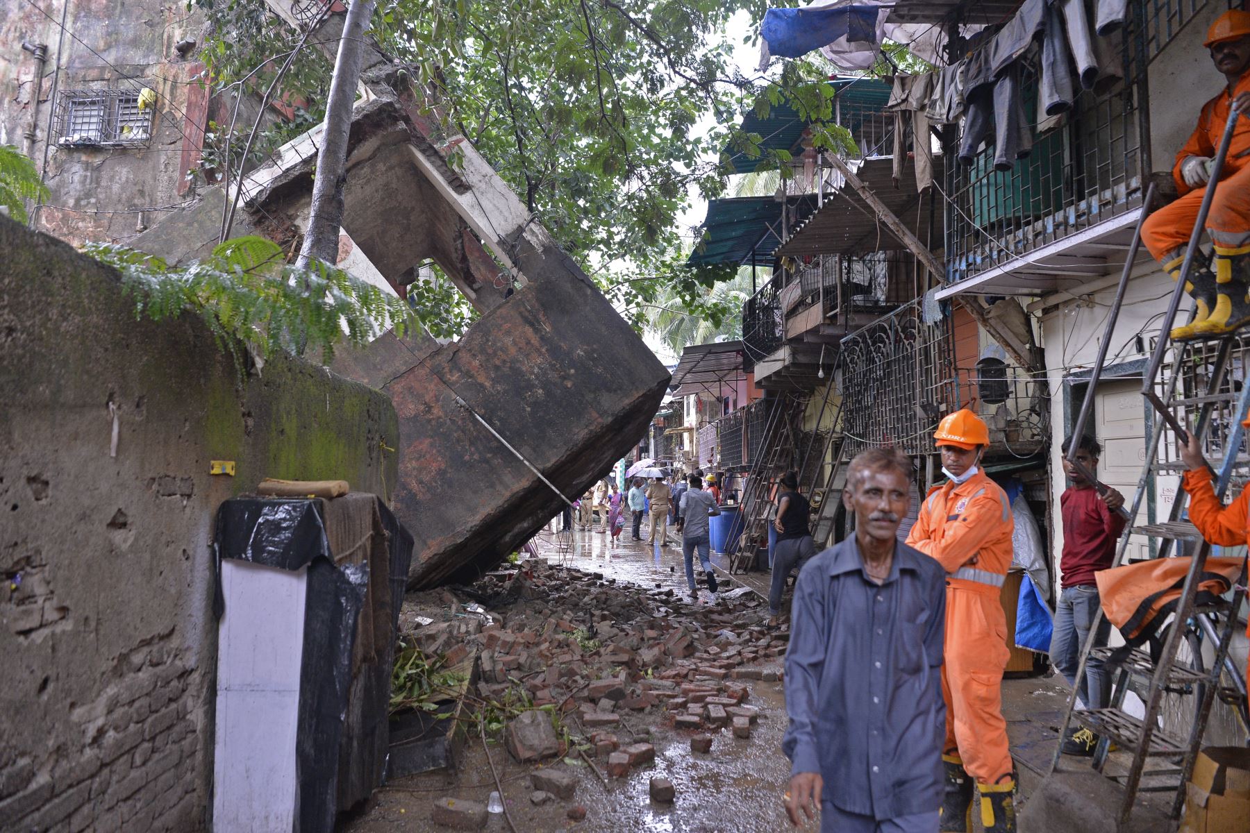 Policías pasan junto al edificio derrumbado en Mumbai. Al menos 14 personas murieron después de que las lluvias monzónicas provocaran el derrumbe de un edificio de cuatro pisos. Foto: AFP