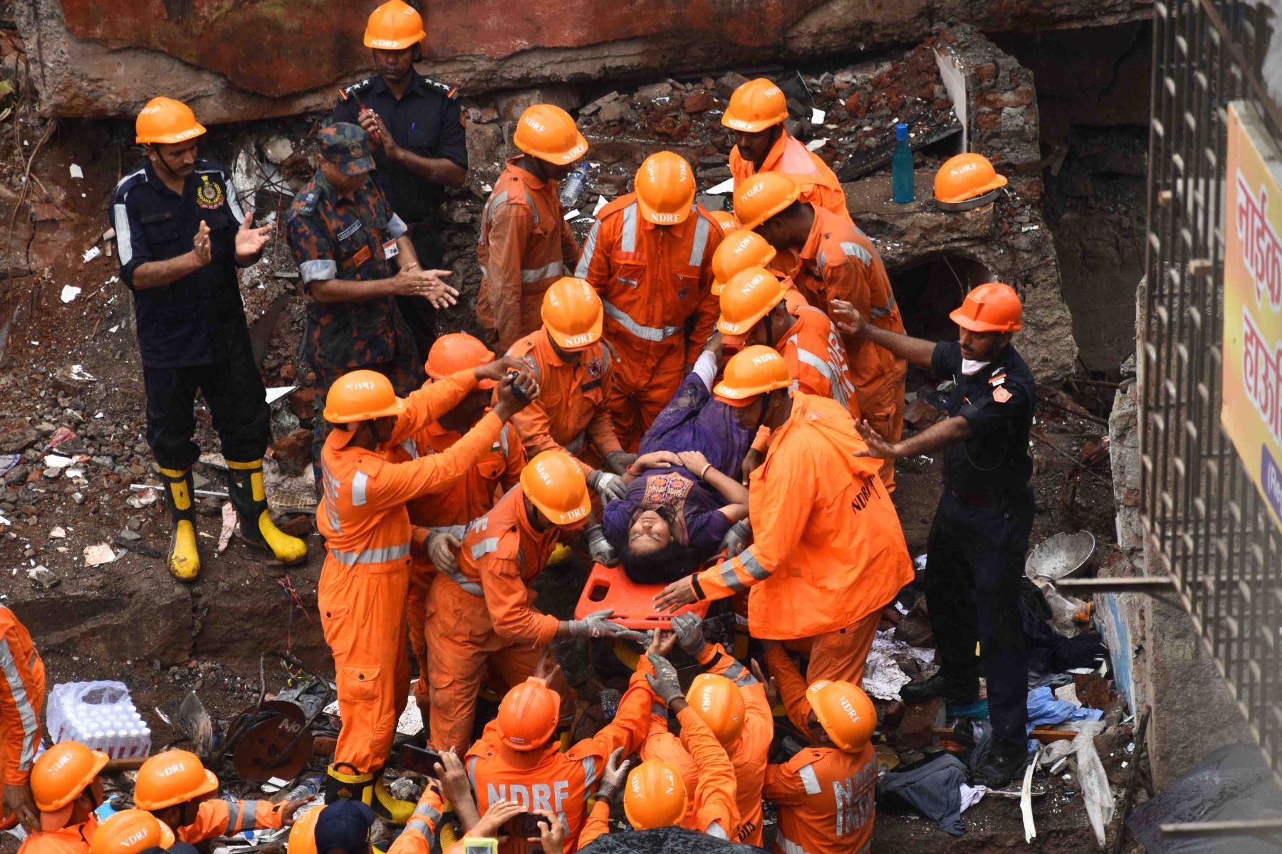 Equipos de rescate aplauden cuando un sobreviviente es encontrado con vida en los escombros de un edificio derrumbado en Mumbai. Foto: AFP