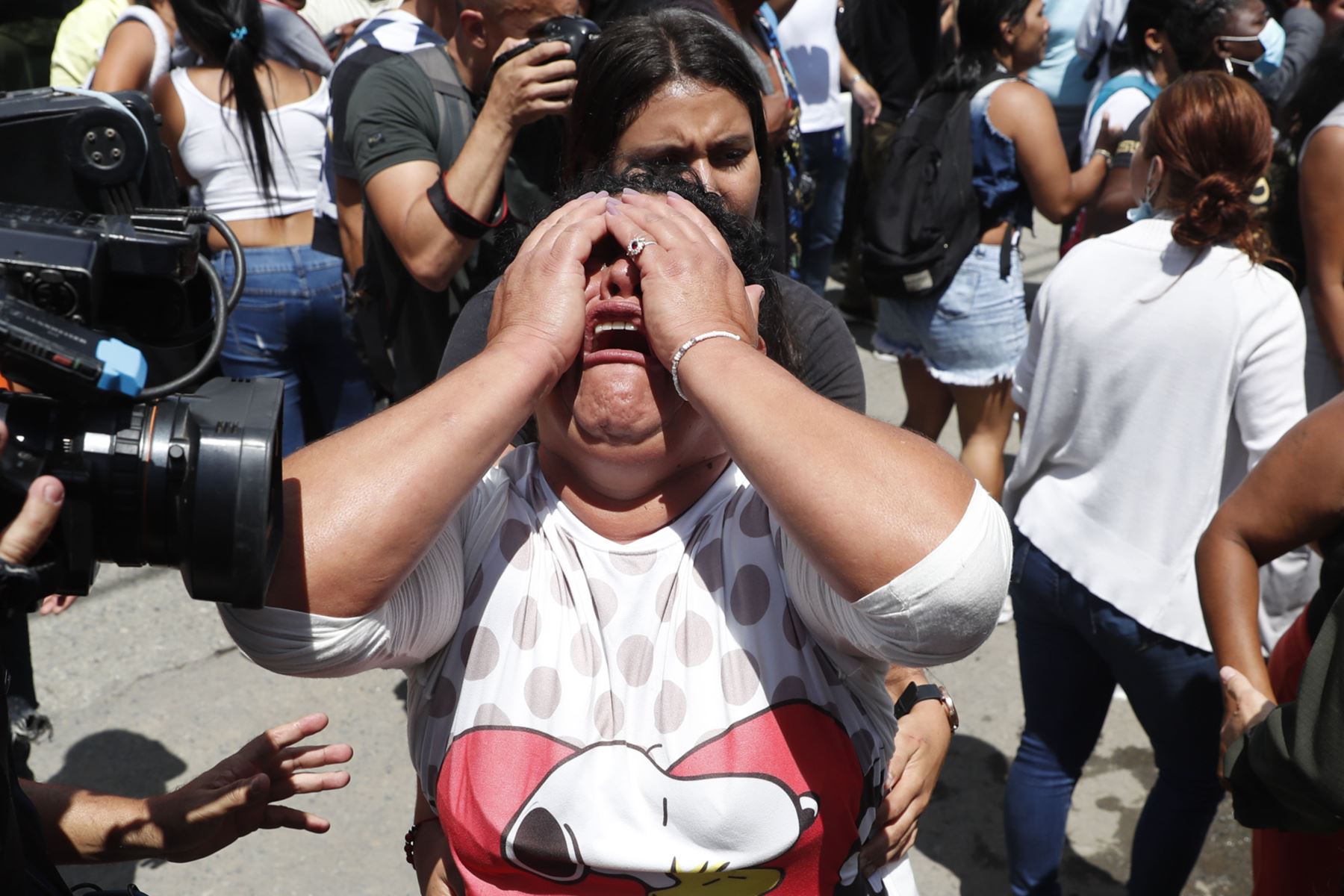 Una mujer llora mientras familiares y amigos de reclusos, que intentan saber sobre el estado de salud de los detenidos, se enfrentan a integrantes del Escuadrón Móvil Antidisturbios (ESMAD) en la entrada de la cárcel de Tuluá en Colombia.
Foto: EFE