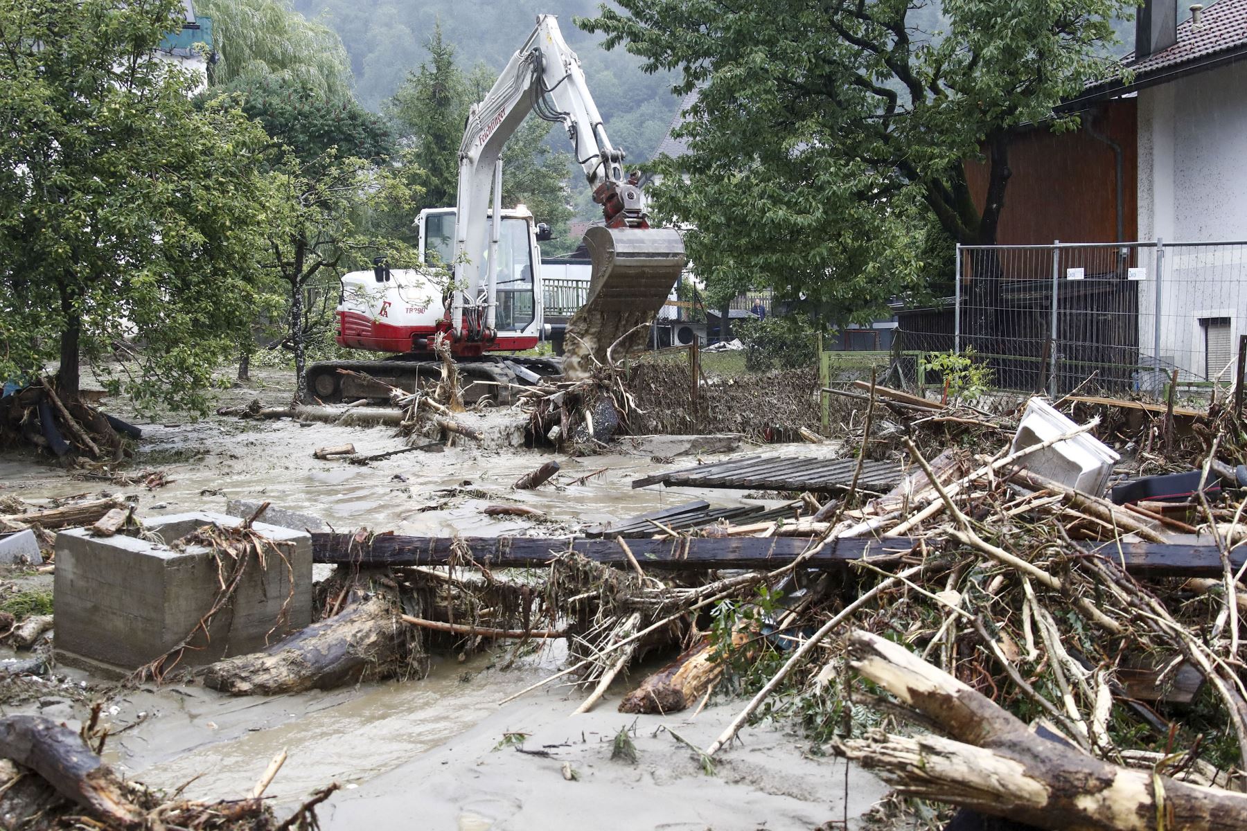 Una excavadora intenta despejar un camino luego de deslizamientos de tierra luego de fuertes lluvias en Treffen, en el distrito de Villach-Land del estado de Carintia, Austria, el 29 de junio de 2022. Foto: AFP