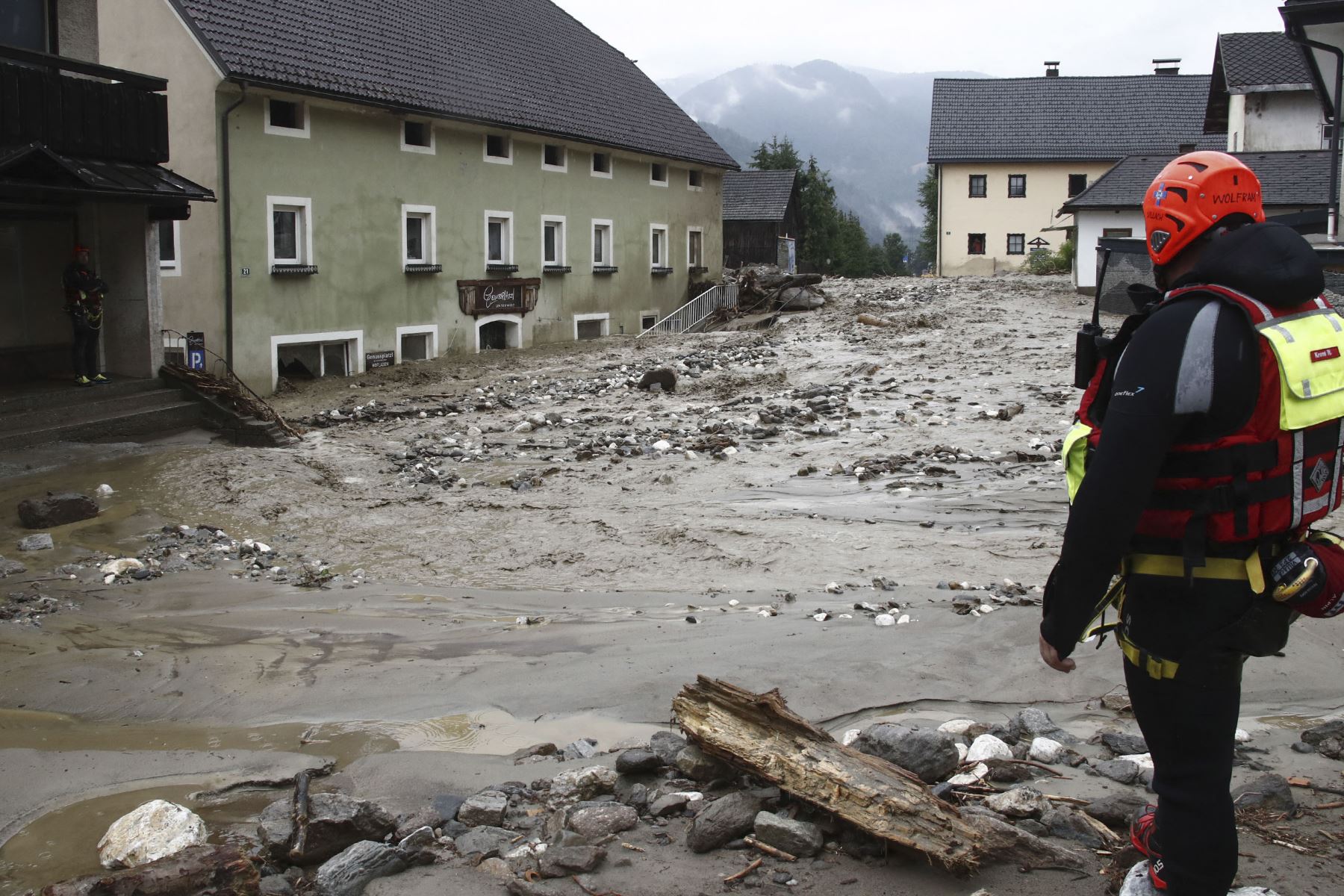 Los equipos de rescate se interponen entre un deslizamiento de tierra, madera, escombros y agua entre las casas dañadas después de las fuertes lluvias en Treffen, en el distrito de Villach-Land del estado de Carintia, Austria, el 29 de junio de 2022. Foto: AFP
