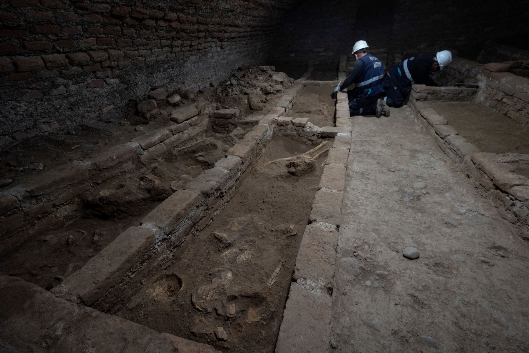 Arqueólogos peruanos descubren restos humanos en fosas comunes en catacumbas subterráneas, durante los trabajos de restauración en el Santuario de Nuestra Señora de la Soledad del siglo XVII, en el centro histórico de Lima.
Foto: AFP