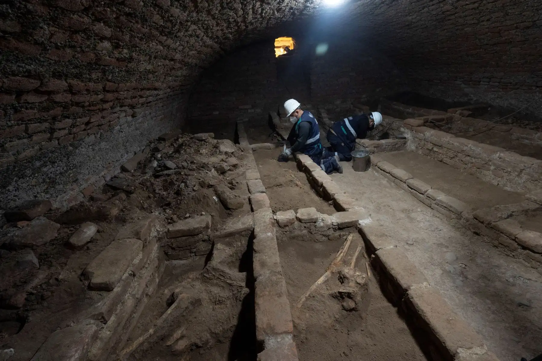 Arqueólogos peruanos descubren restos humanos en fosas comunes en catacumbas subterráneas, durante los trabajos de restauración en el Santuario de Nuestra Señora de la Soledad del siglo XVII, en el centro histórico de Lima.
Foto: AFP