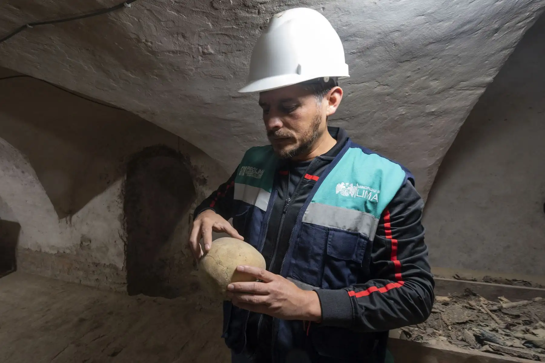 El arqueólogo peruano Hugo Benavides sostiene el presunto cráneo de una niña andina encontrado durante los trabajos de restauración en el Santuario colonial de Nuestra Señora de la Soledad del siglo XVII, junto con otros restos humanos enterrados en fosas comunes en catacumbas subterráneas, en el centro histórico de Lima.
Foto: AFP