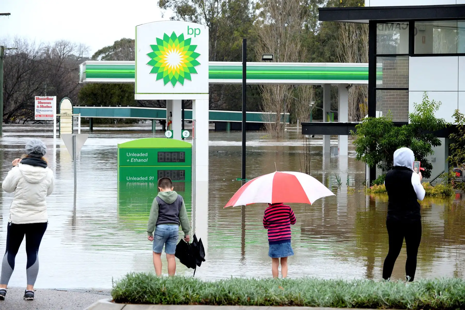 La gente se para junto a una gasolinera inundada debido a la lluvia torrencial en el suburbio de Camden en Sydney.
Foto: AFP