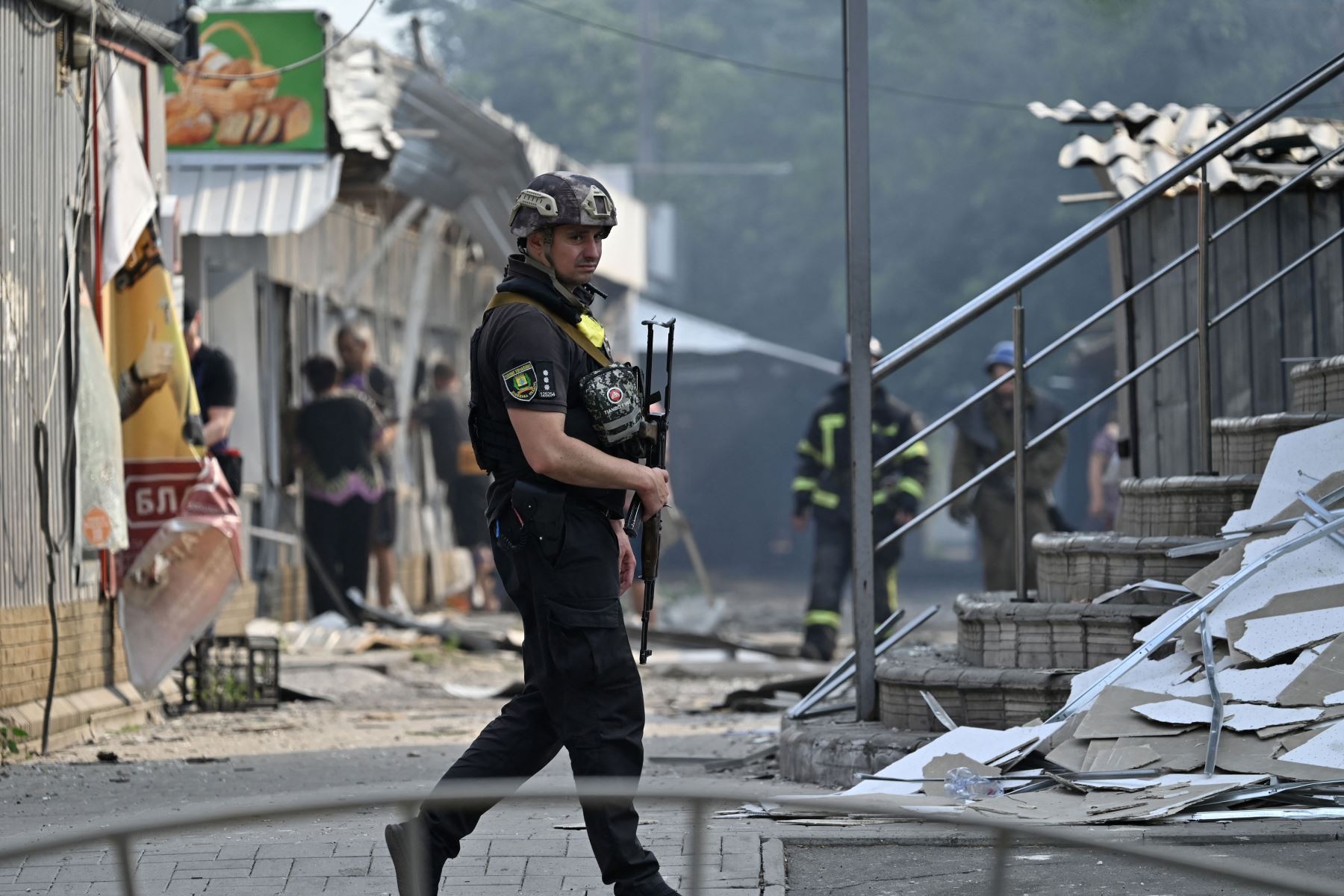 Un policía ucraniano patrulla frente a tiendas destruidas en un mercado local después de un ataque con cohetes en la ciudad ucraniana de Sloviansk.
Foto: AFP