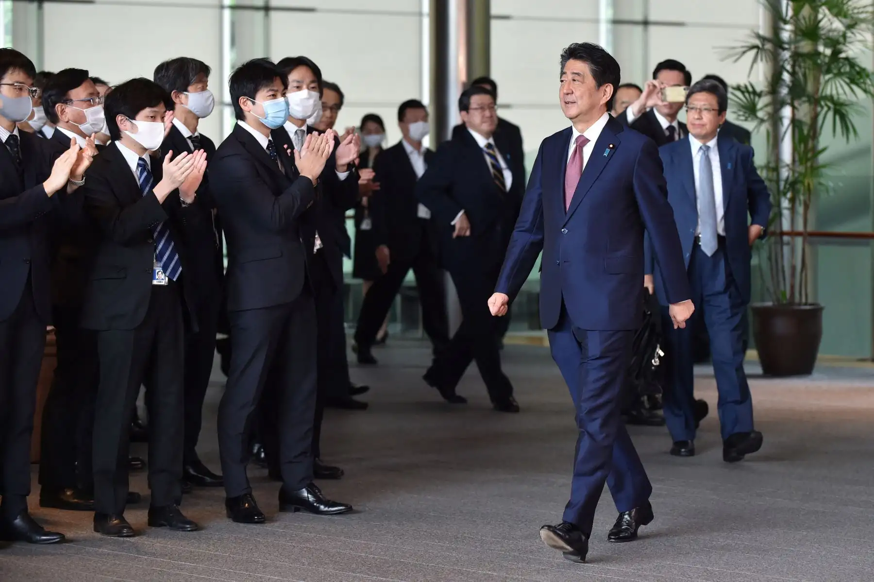 El primer ministro saliente de Japón, Shinzo Abe (R), se despide de los miembros del personal después de la última reunión del gabinete en Tokio el 16 de septiembre de 2020. 
Foto: AFP