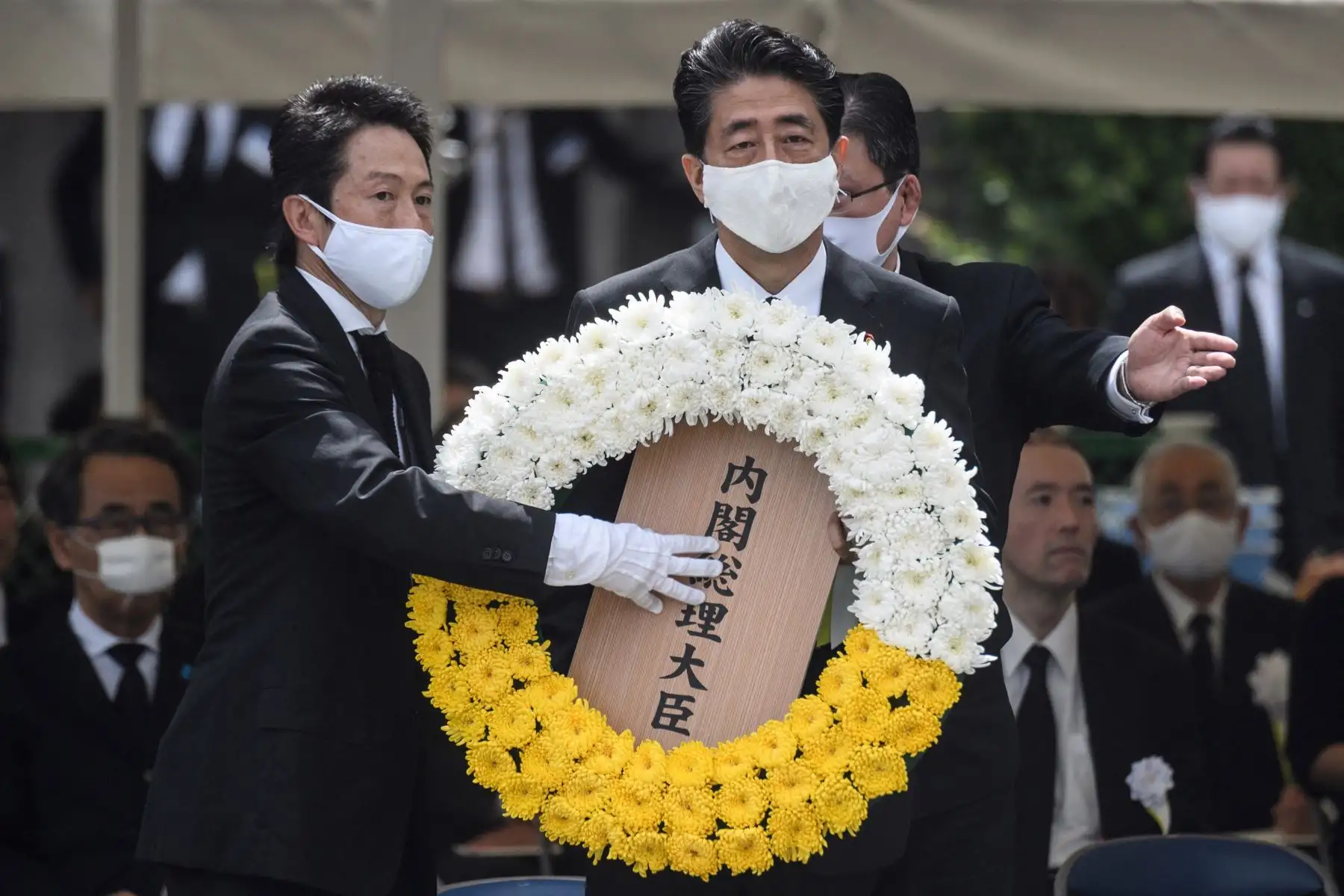 El primer ministro japonés, Shinzo Abe, deposita una ofrenda floral durante una ceremonia que marca el 75 aniversario del bombardeo atómico de Nagasaki, en el Parque de la Paz de Nagasaki el 9 de agosto de 2020. 
Foto: AFP