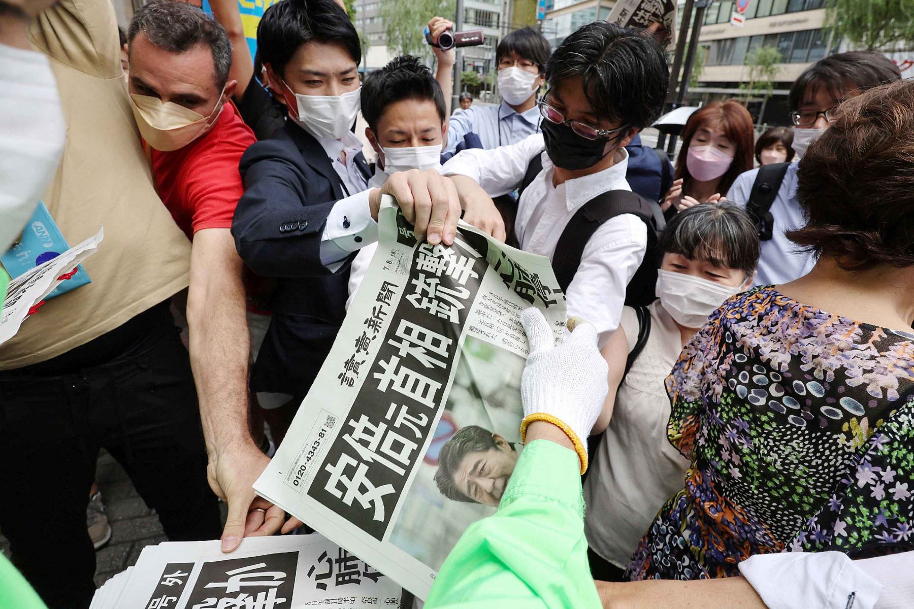 La gente se aglomera para recoger un periódico adicional que informa sobre el tiroteo del ex primer ministro japonés Shinzo Abe, en Tokio. Foto: AFP