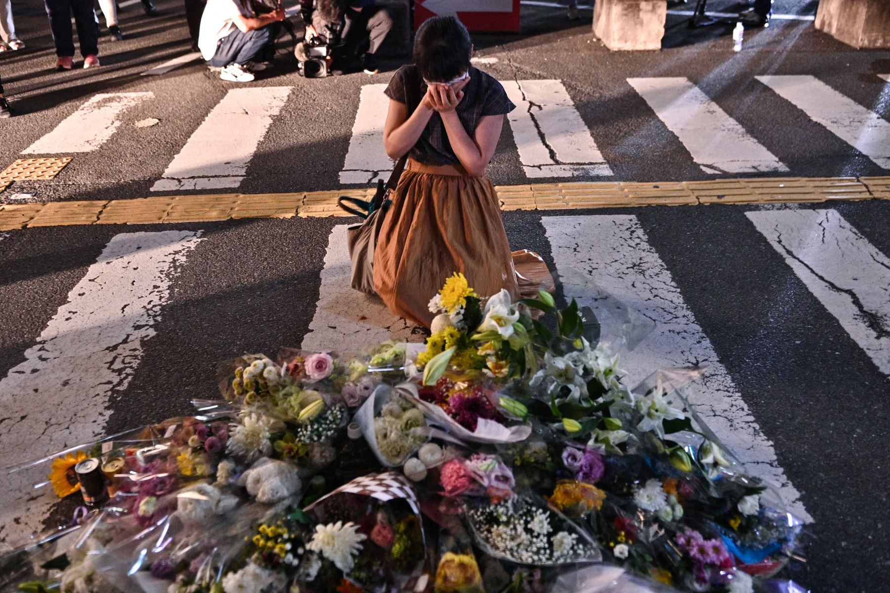 Una mujer coloca flores en la estación Yamato-Saidaiji en Nara, donde el ex primer ministro japonés Shinzo Abe, recibió un disparo. Abe fue declarado muerto el 8 de julio. Foto: AFP