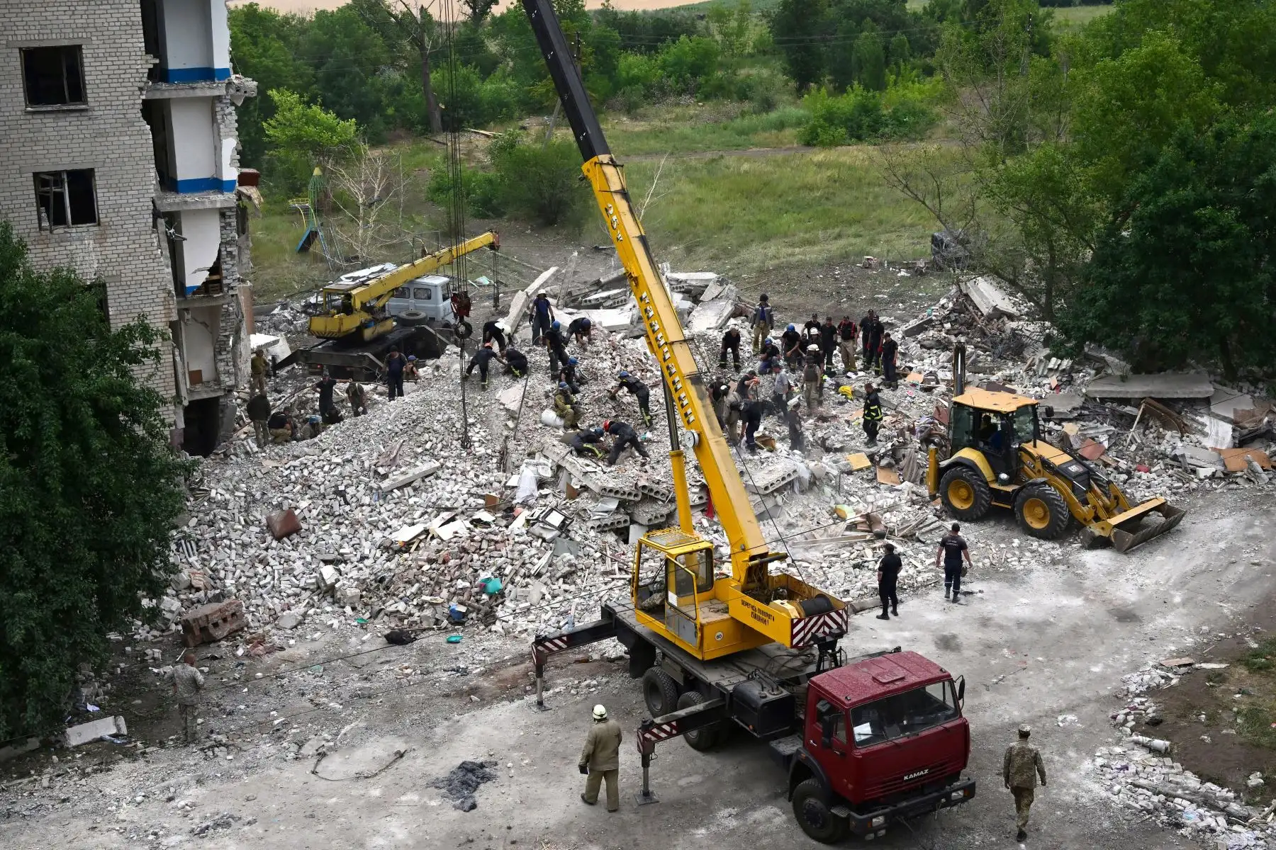 Bomberos y miembros de un equipo de rescate buscan entre los escombros después de que un edificio fuera parcialmente destruido tras un bombardeo, en Chasiv Yar, en el este de Ucrania.
Foto: AFP
