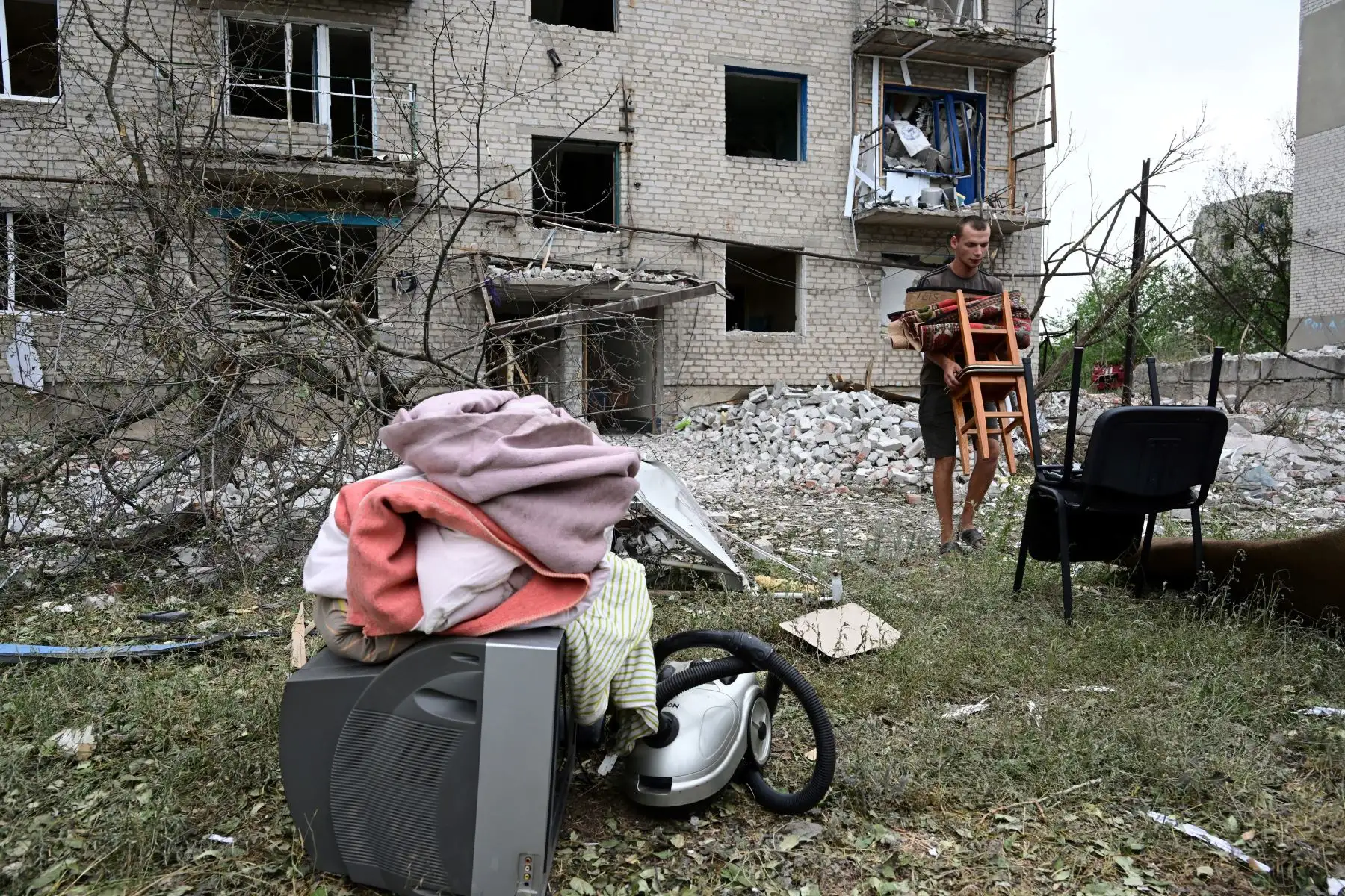 Un habitante saca sus pertenencias de su apartamento después de que un edificio fuera parcialmente destruido tras un bombardeo, en Chasiv Yar, al este de Ucrania.
Foto: AFP