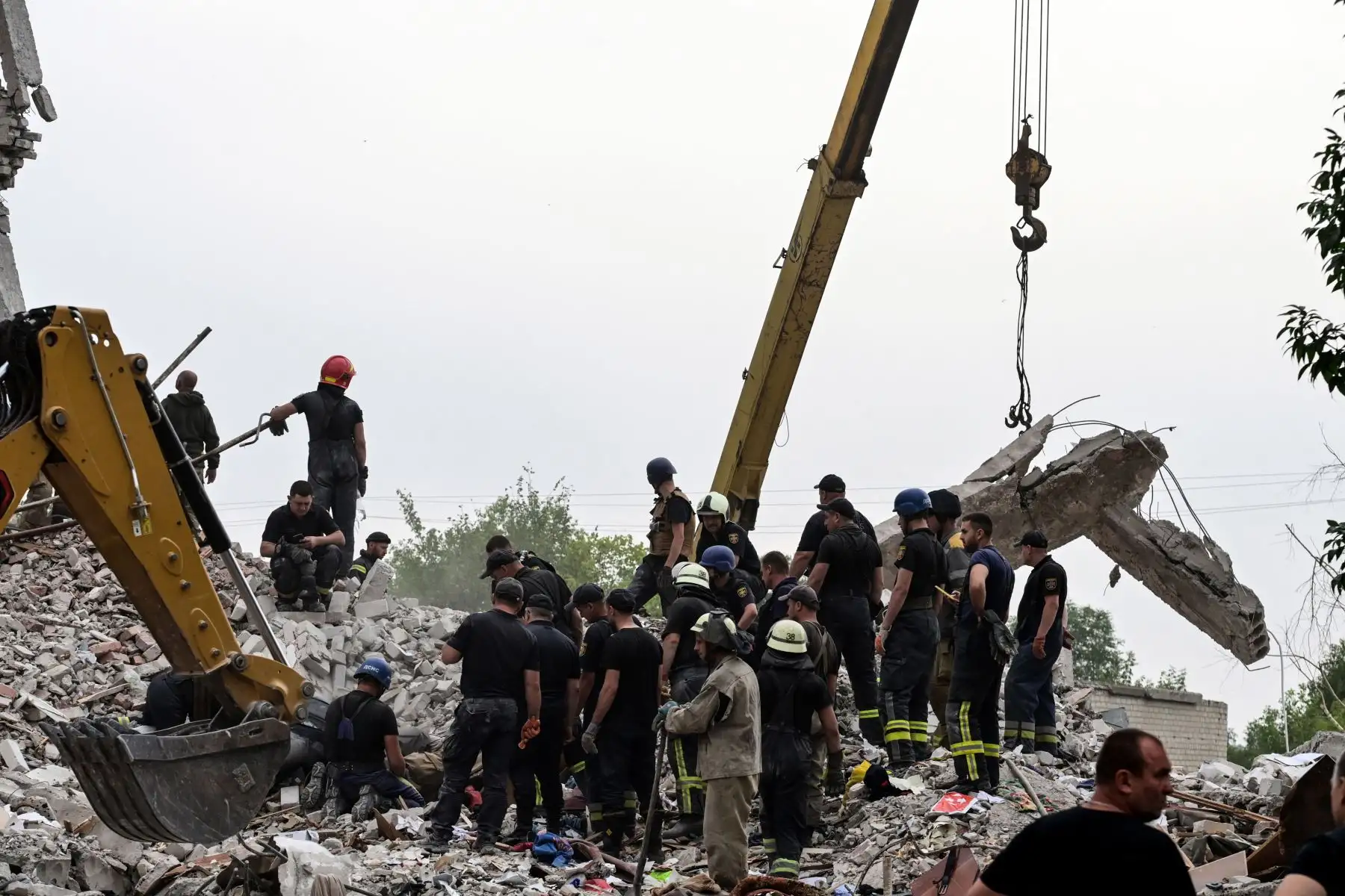 Bomberos y miembros de un equipo de rescate buscan entre los escombros después de que un edificio fuera parcialmente destruido tras un bombardeo, en Chasiv Yar, en el este de Ucrania.
Foto: AFP