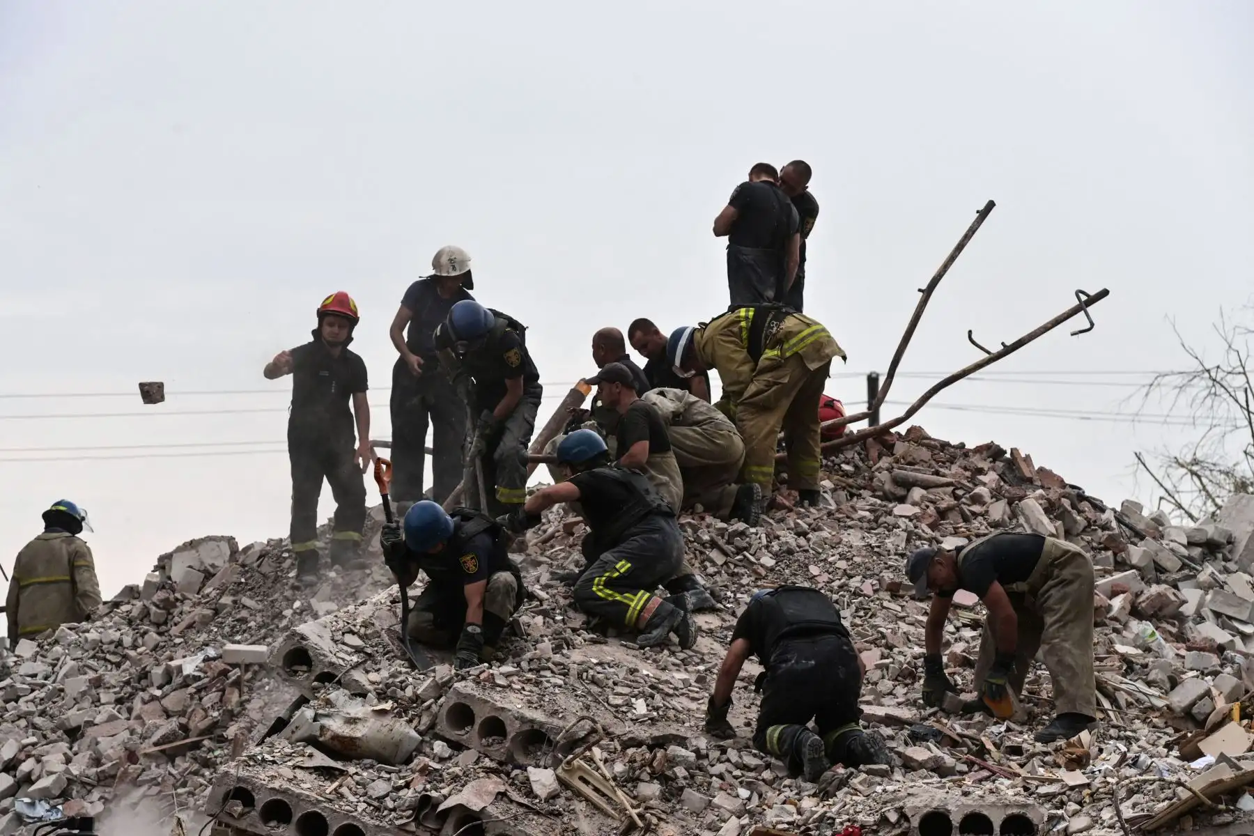 Bomberos y miembros de un equipo de rescate limpian la escena después de que un edificio fuera parcialmente destruido luego de un bombardeo, en Chasiv Yar, este de Ucrania.
Foto: AFP