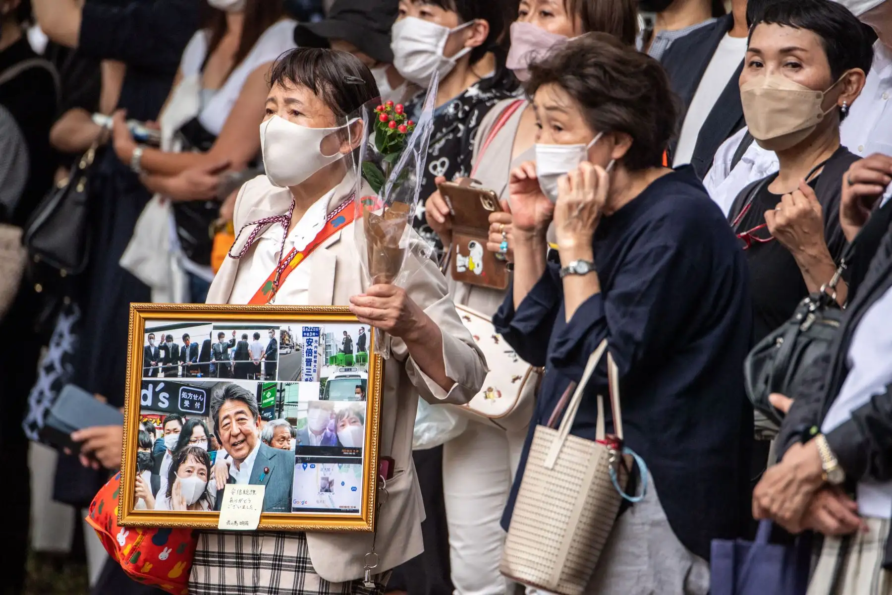 La gente se reúne para observar el coche fúnebre que lleva al difunto primer ministro japonés Shinzo Abe que sale del Templo Zojoji en Tokio.
Foto: AFP