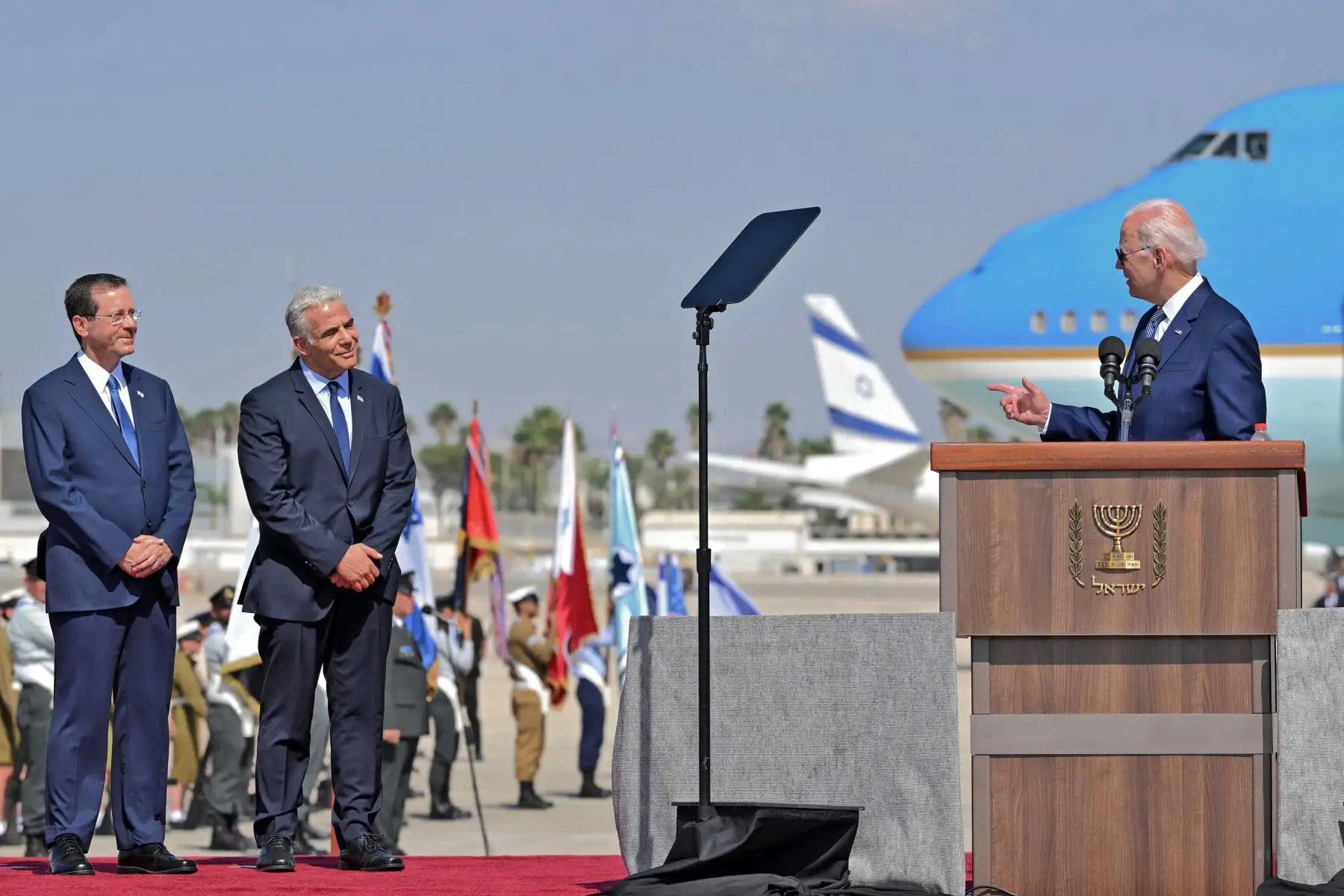 El presidente de Israel, Isaac Herzog, y el primer ministro interino, Yair Lapid, escuchan al presidente de los Estados Unidos, Joe Biden, mientras se dirige a sus anfitriones a su llegada al aeropuerto Ben Gurion en Lod, cerca de Tel Aviv. Foto: AFP