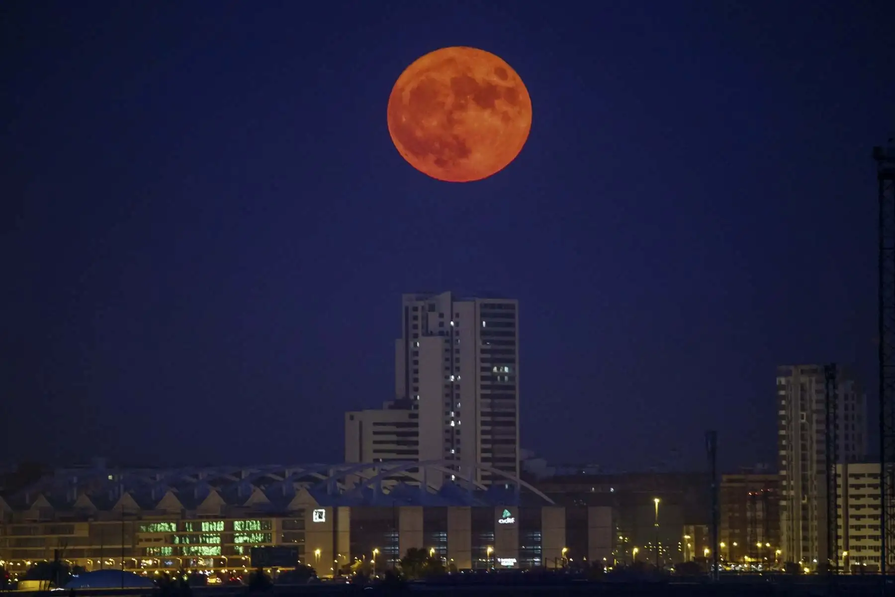 La luna llena sale junto al edificio Torre Zaragoza en la capital aragonesa. La luna llena de julio es también la primera del verano y la mas grande del año. Foto: EFE