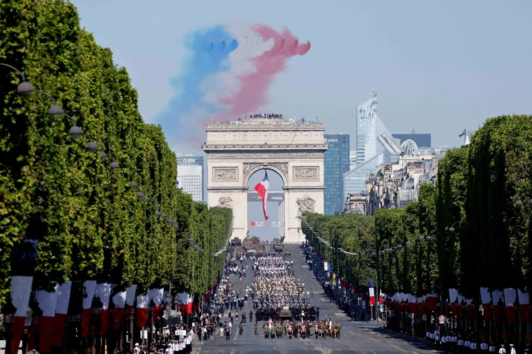 El equipo de vuelo acrobático de élite francés "Patrouille de France" lanza humo con los colores de la bandera francesa mientras realizan un sobrevuelo durante el desfile militar del Día de la Bastilla en la avenida de los Campos Elíseos en París. Foto: AFP