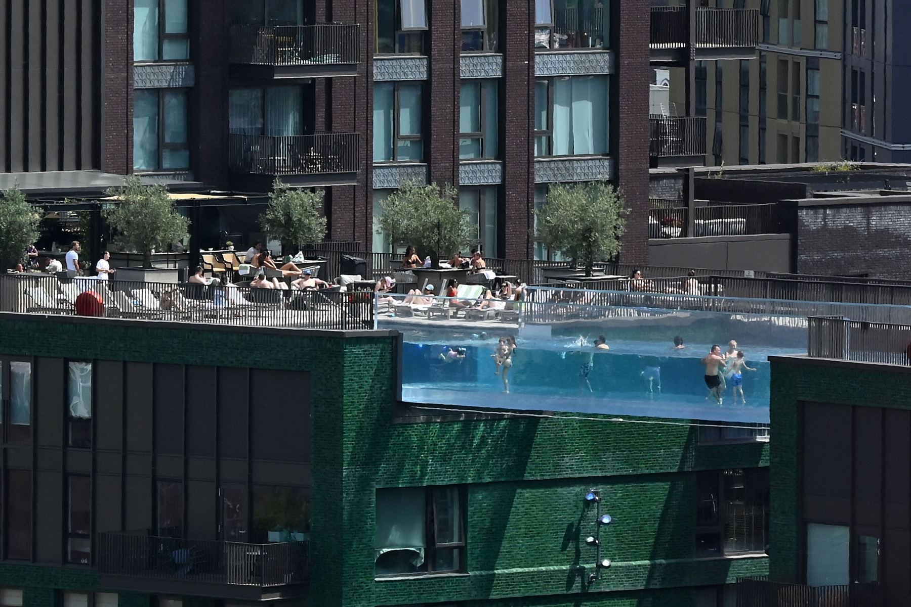 La gente nada en Sky Pool, un puente de piscina de acrílico transparente que se fija entre dos bloques de apartamentos, en Embassy Gardens en el suroeste de Londres.
Foto: AFP