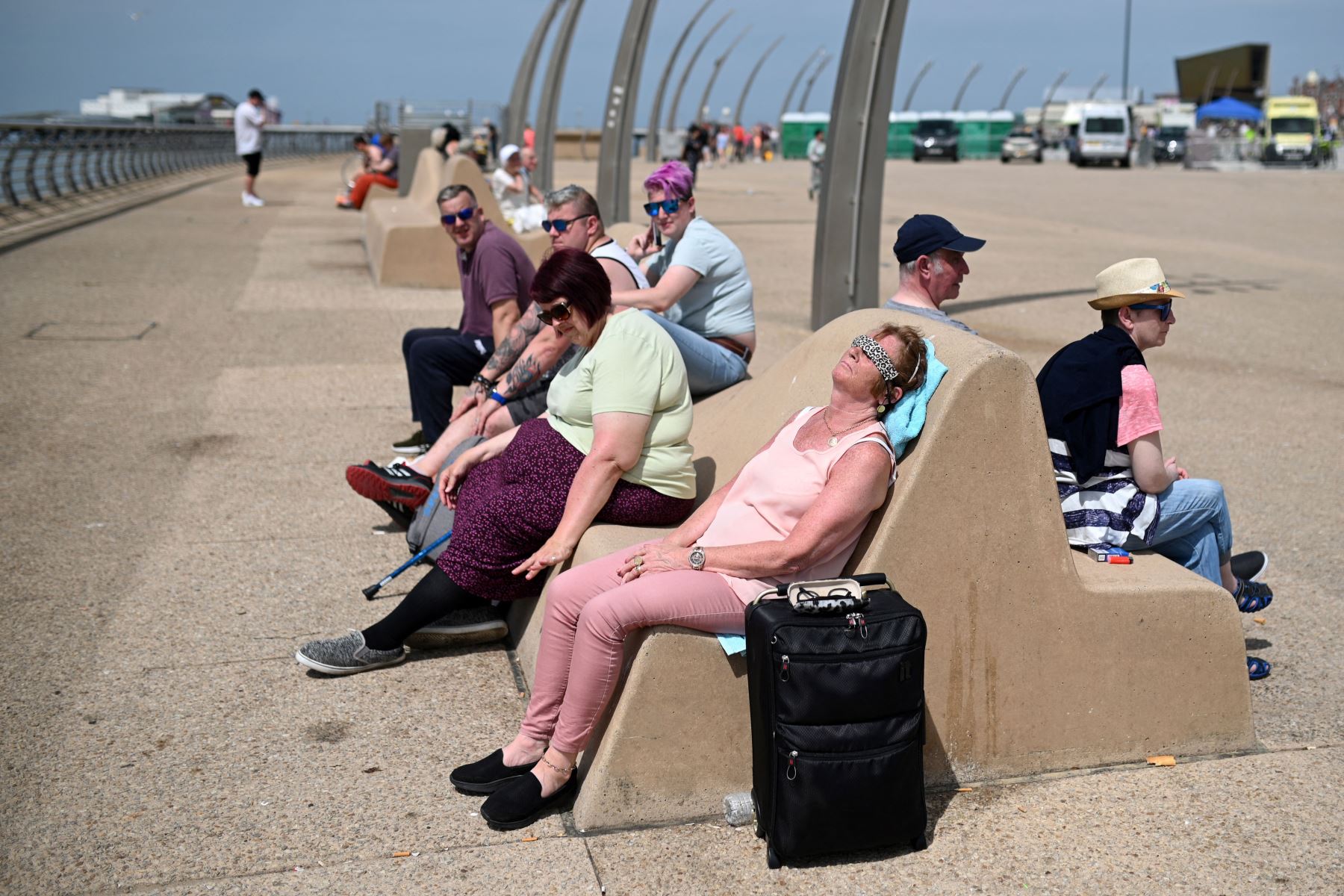La gente disfruta del sol en el paseo marítimo de Blackpool, en el noroeste de Inglaterra.
Foto: AFP