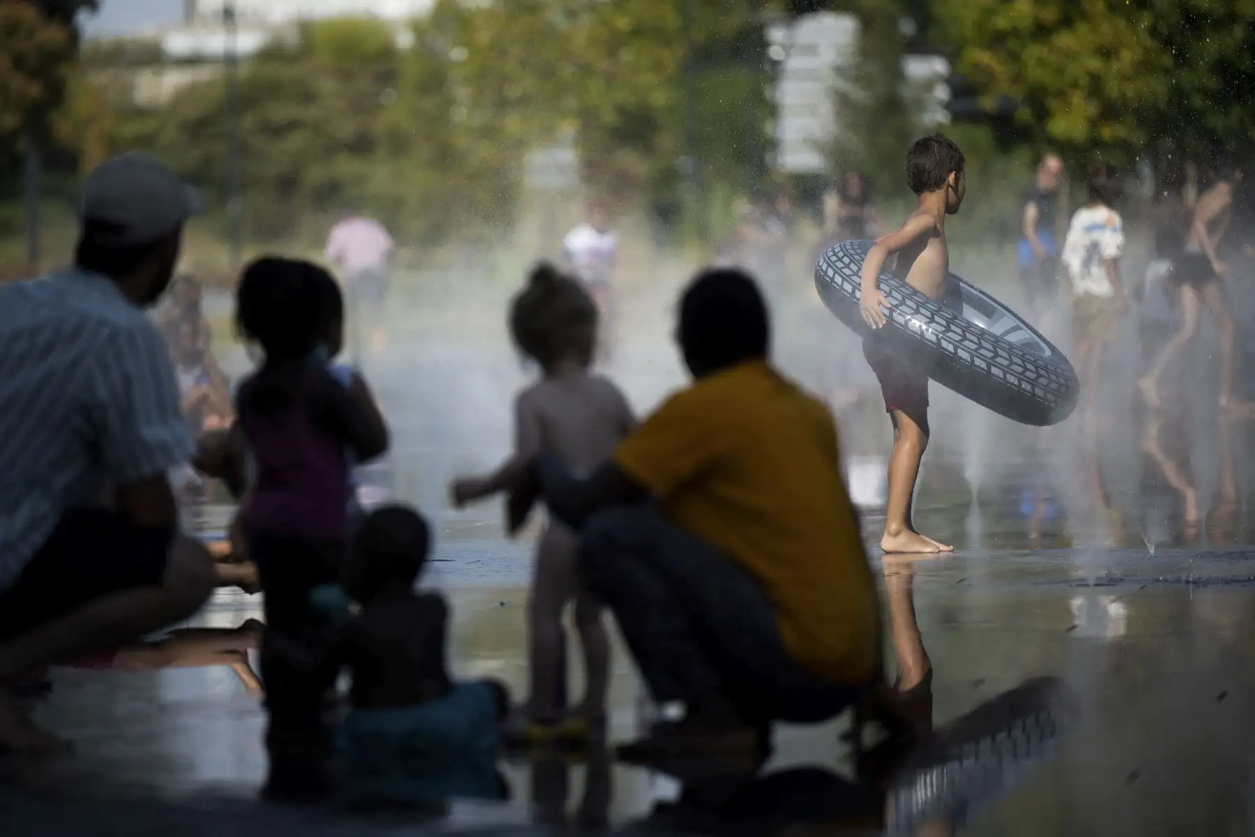 La gente se refresca con el agua de una fuente; cuando la temperatura del aire supera los 42 grados centígrados en Nantes, Francia. Foto: AFP