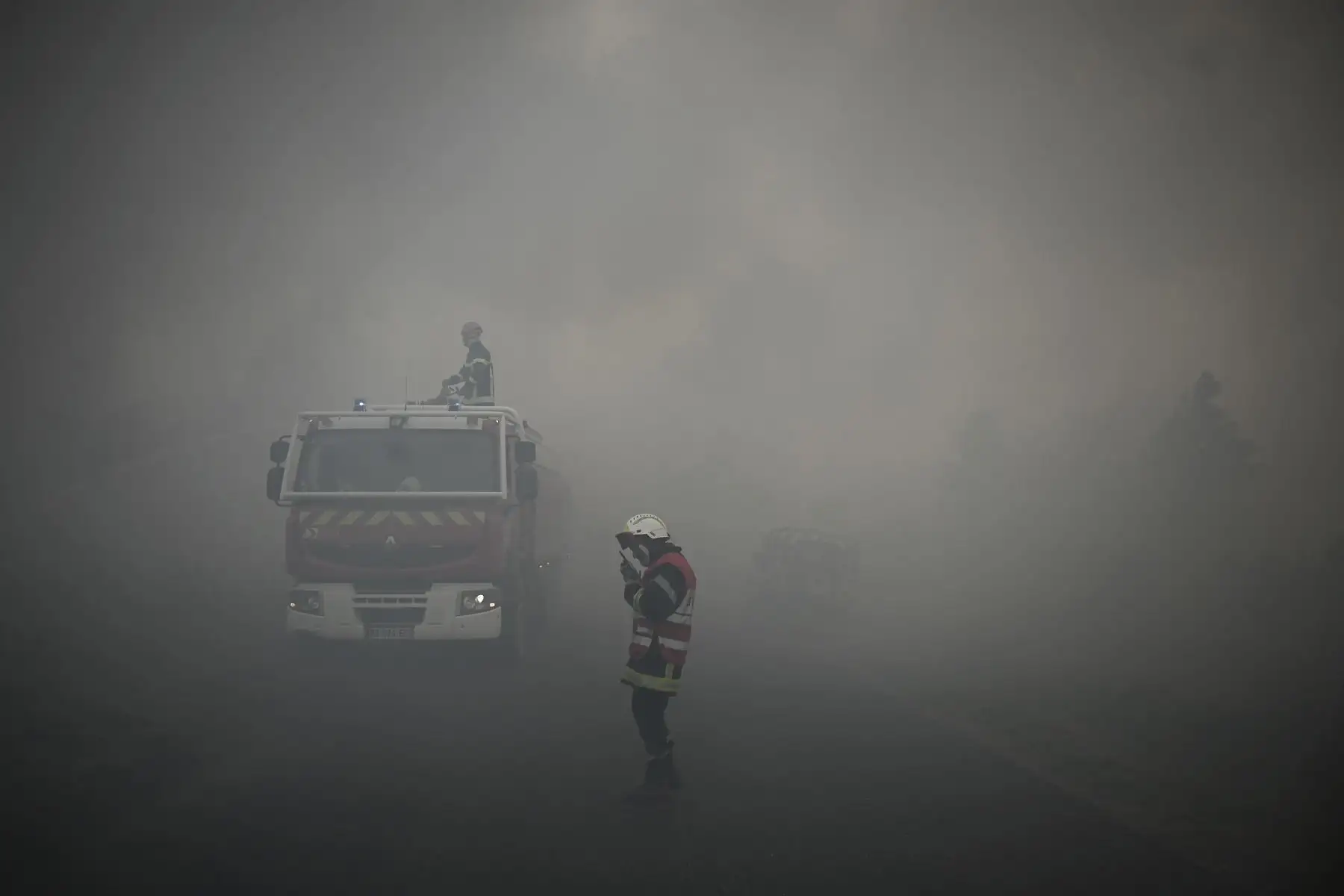 Los bomberos toman posiciones mientras se eleva el humo de un incendio forestal cerca de Louchats, a unos 35 km de Landiras, en Gironde, suroeste de Francia. Foto: AFP