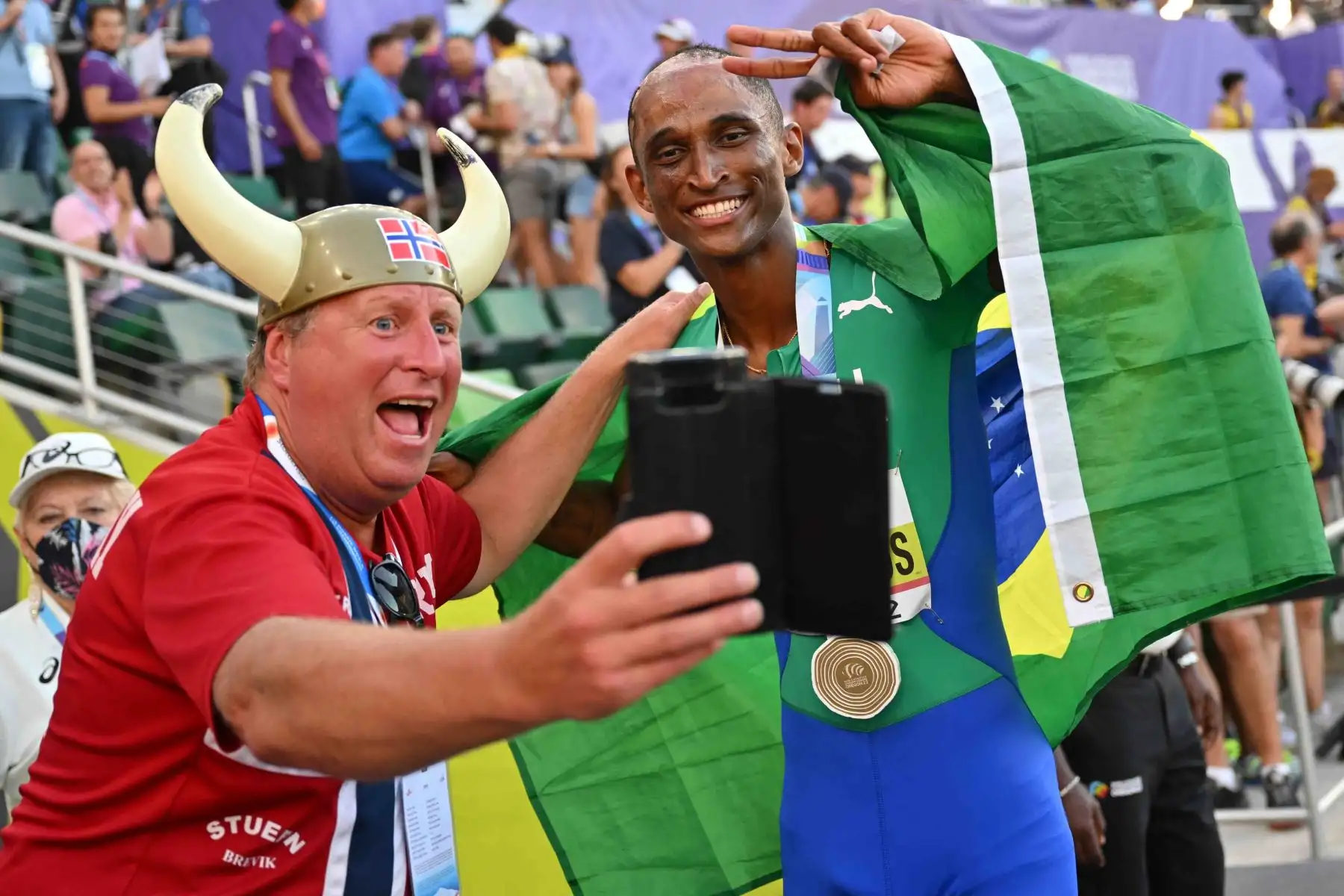 Brasileño Alison Dos Santos, posa para una selfie con un fanático después de ganar la final masculina de 400 m con vallas durante el Campeonato Mundial de Atletismo en Hayward Field en Eugene, Oregón. Foto: AFP