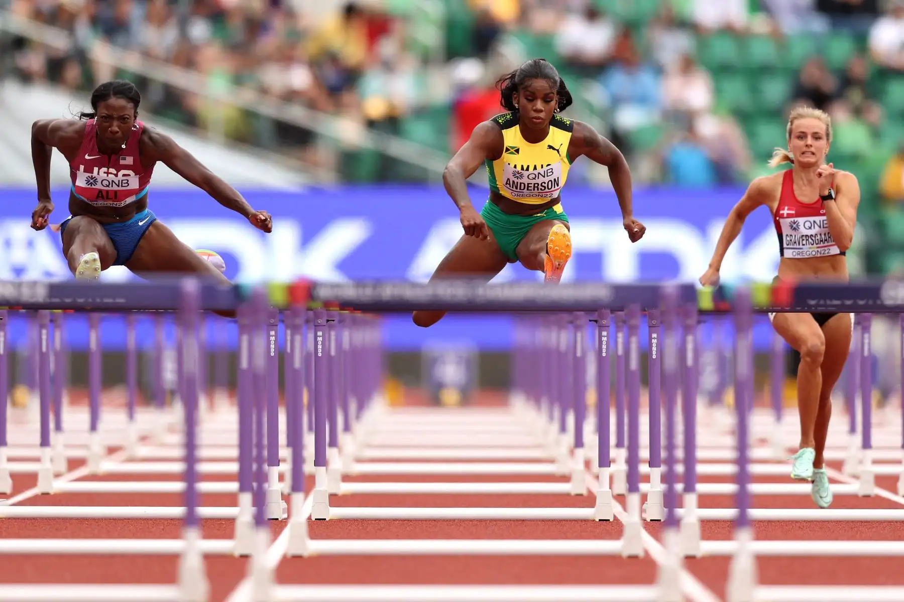 Nia Ali del equipo de Estados Unidos, Britany Anderson del equipo de Jamaica y Mette Graversgaard del equipo de Dinamarca compiten en las eliminatorias de 100 m vallas femeninas el noveno día del Campeonato Mundial de Atletismo Oregon22 en Hayward Field.
Foto: AFP
