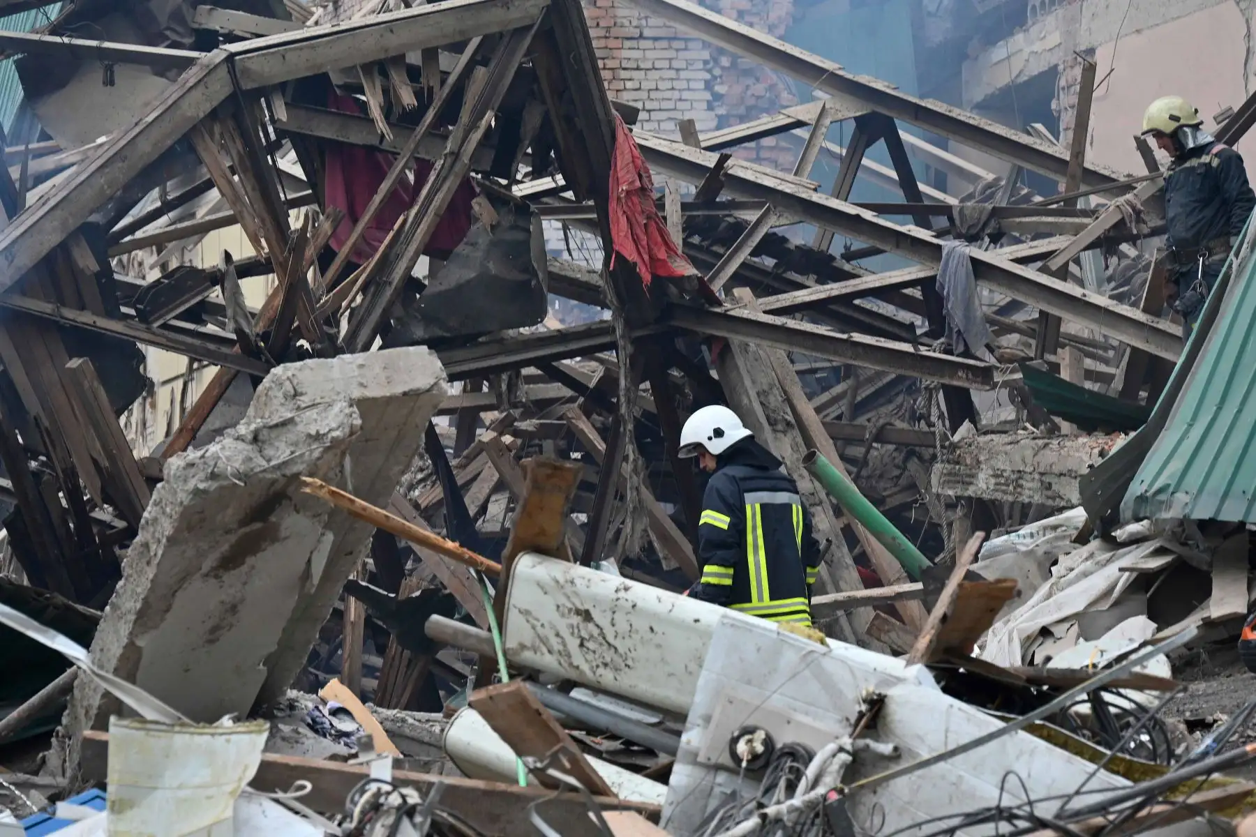 Equipos de rescate cavan entre los escombros de los edificios destruidos en ataques nocturnos en busca de sobrevivientes, en la ciudad de Chuhuiv, región de Kharkiv. Foto: AFP
