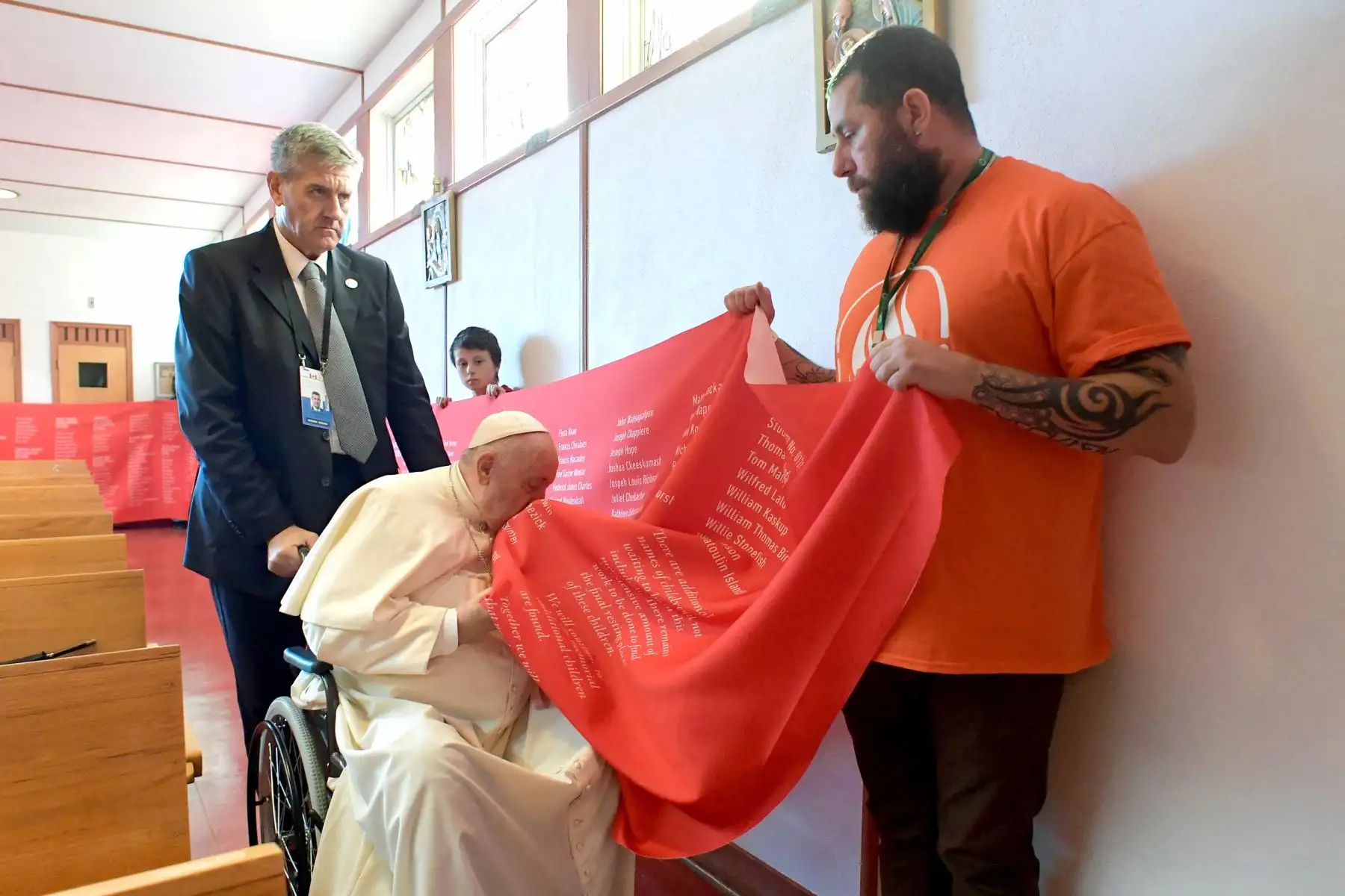 El Papa Francisco besa una pancarta con los nombres de las víctimas de abusos cometidos en las escuelas residenciales administradas por la Iglesia Católica, en la iglesia Notre-Dame des Sept Douleurs. Foto: AFP