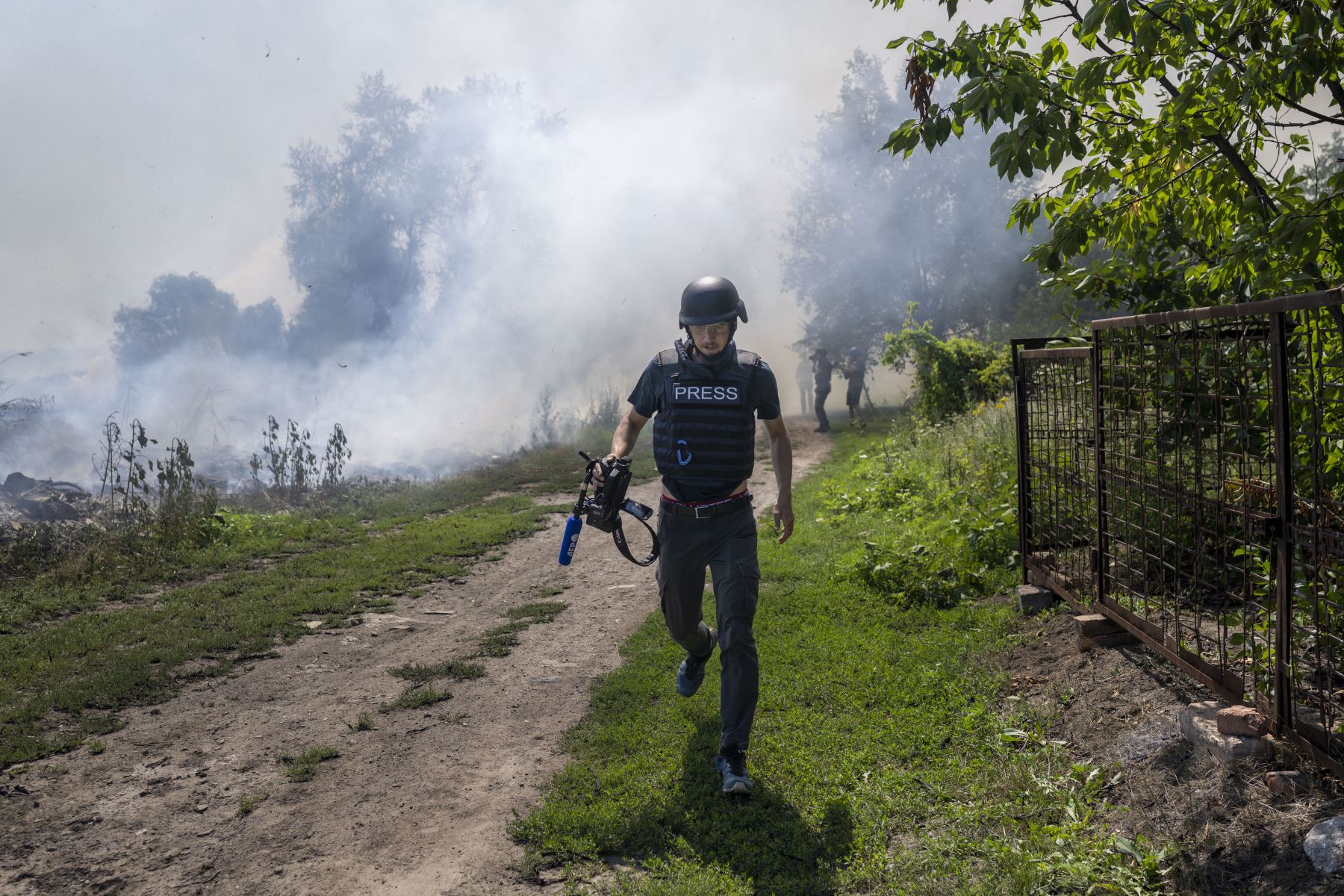 Un periodista de la AFP corre mientras el humo se eleva tras un bombardeo en Bajmut, en el este de Ucrania (imagen de julio de 2022). Foto: AFP