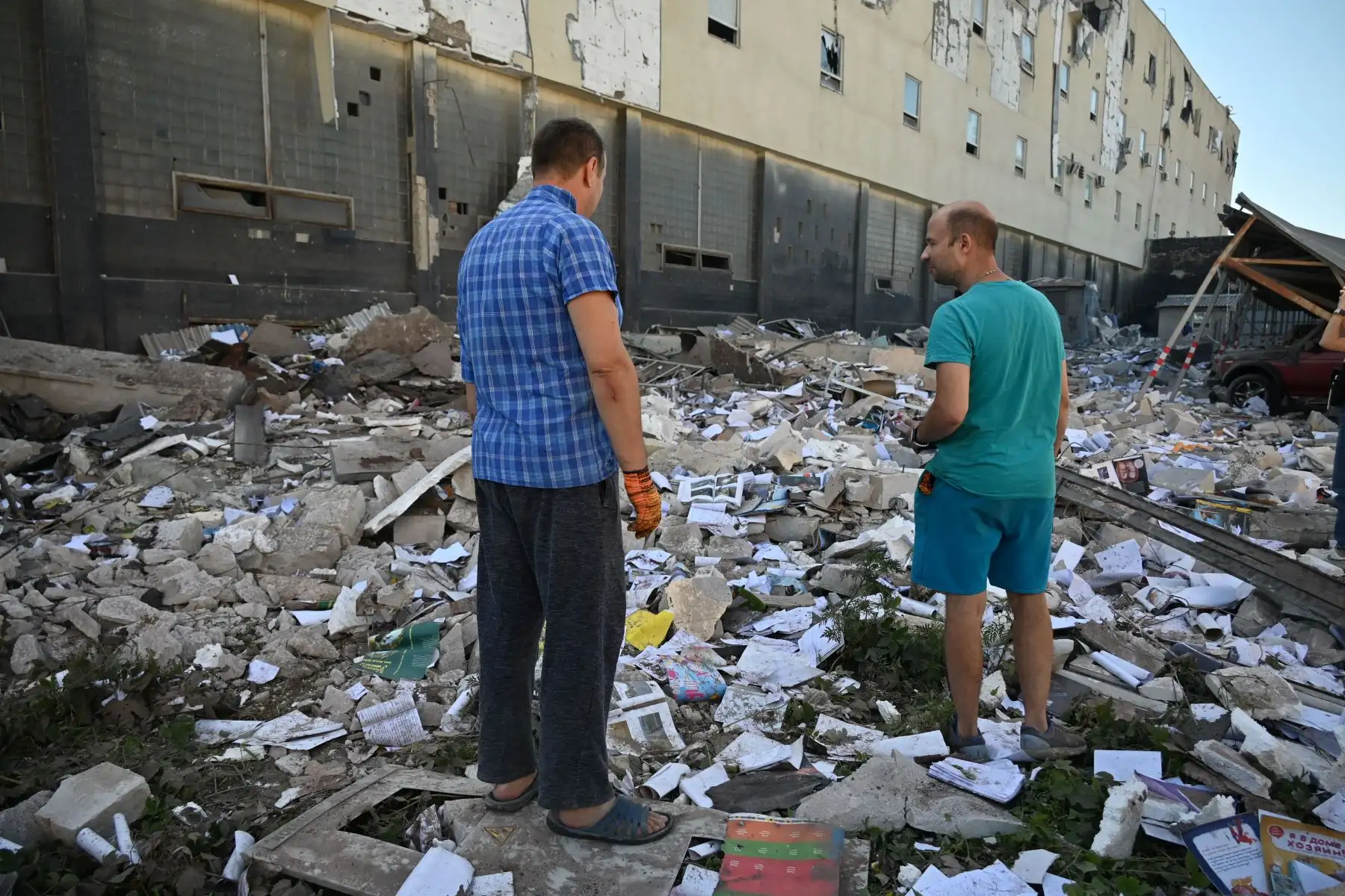 Los residentes locales asisten cerca de Press House, un complejo de una imprenta, oficinas editoriales y tiendas en Kharkiv dañado por el ataque con misiles.
Foto: AFP