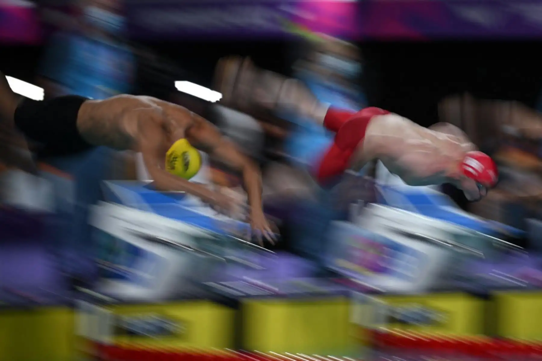 Tom Dean de Inglaterra y Zac Incerti de Australia se sumergen para competir en la semifinal masculina de natación estilo libre de 100 m en el Sandwell Aquatics Centre. Foto: AFP