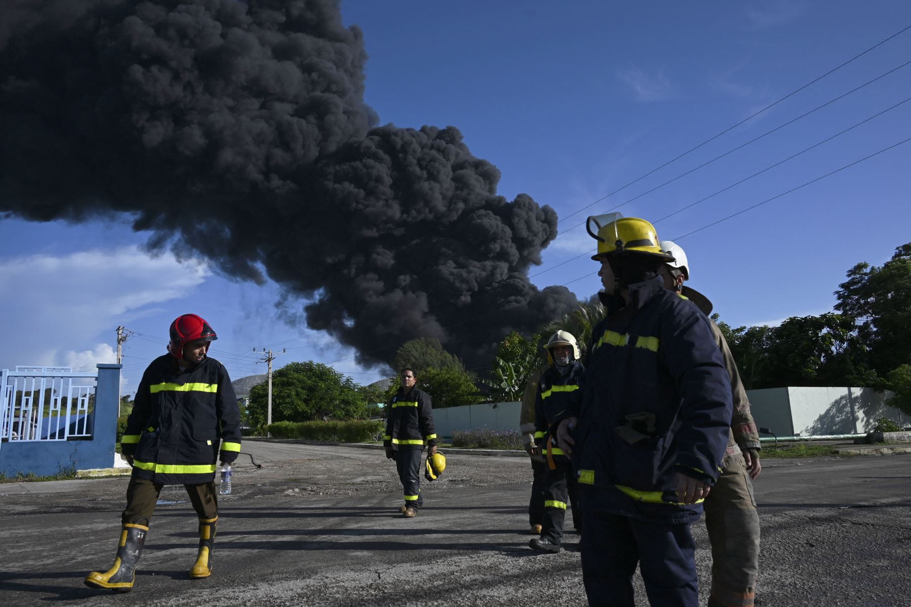 Los bomberos se ven cerca de un tanque de petróleo en llamas en Matanzas, Cuba. El incendio provocado por un rayo el viernes en un depósito de combustible en Matanzas, en el oeste de Cuba, se extendió a un segundo tanque en la madrugada de este sábado y causó 49 heridos, informaron fuentes oficiales.
Foto: AFP