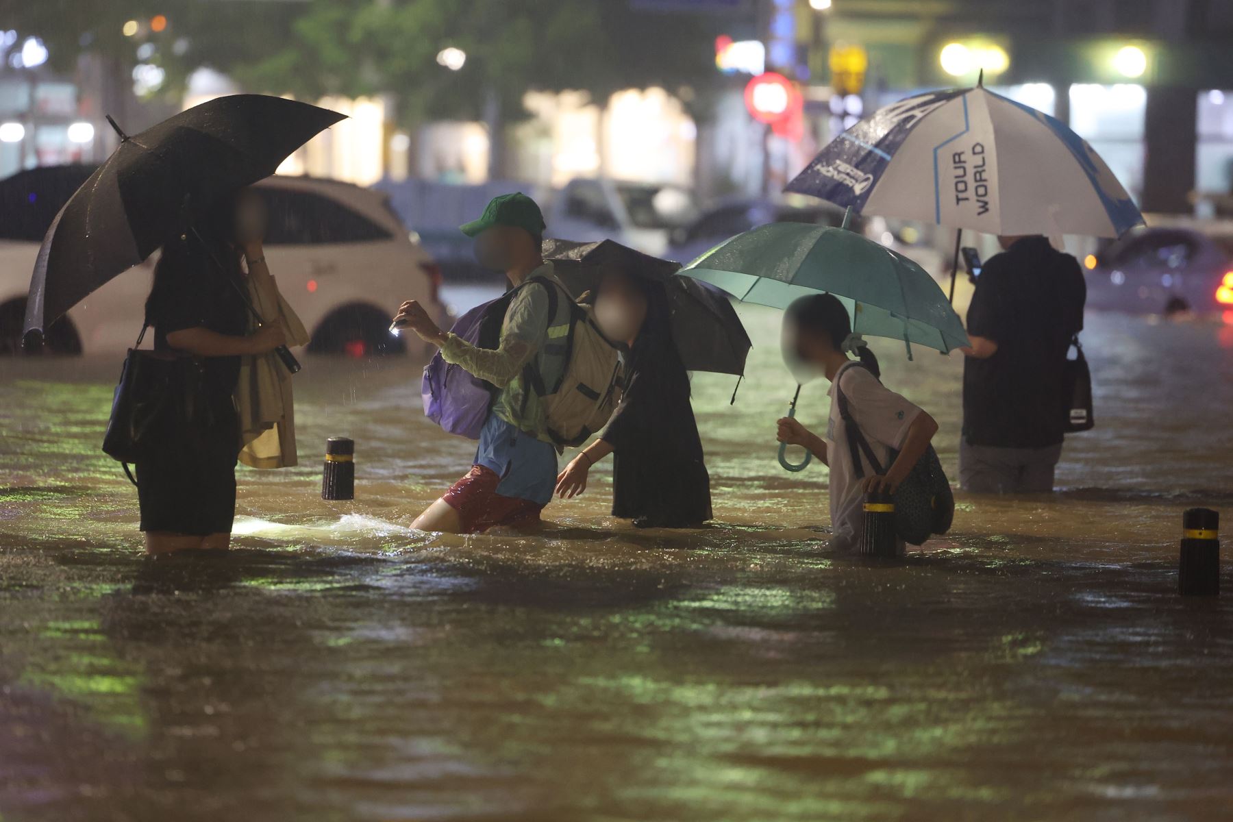Personas caminan por una carretera inundada en el sur de Seúl, Corea del Sur . Fuertes lluvias de más de 100 milímetros por hora, las más intensas en 80 años, azotan Seúl y sus alrededores. 
Foto: EFE