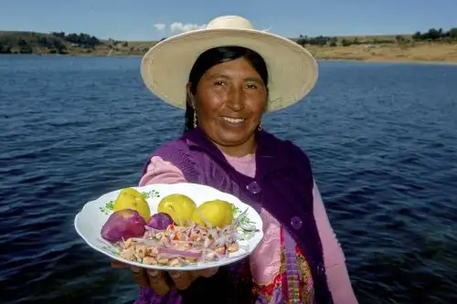 Una mujer indígena muestra un platillo con una versión de ceviche de trucha recién pescado de una finca en el lago Titicaca, en la comunidad indígena aymara de Chucasuyo, en el altiplano andino de Juli, departamento de Puno. Foto de archivo: AFP