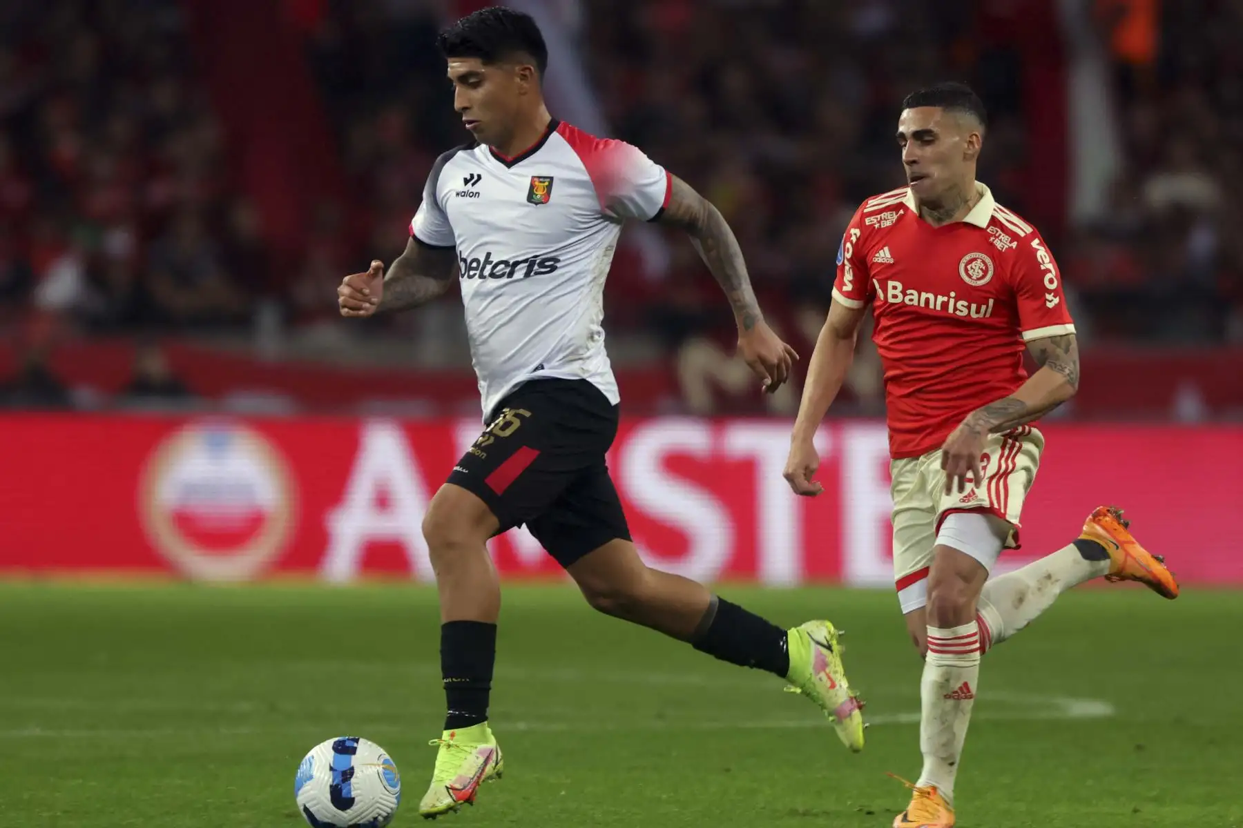 Luis Iberico del equipo peruano de Melgar, es desafiado por el Internacional Gabriel de Brasil durante su partido de vuelta de cuartos de final del torneo de fútbol de la Copa Sudamericana, en el estadio Beira-Rio en Porto Alegre, Brasil. Foto: AFP
