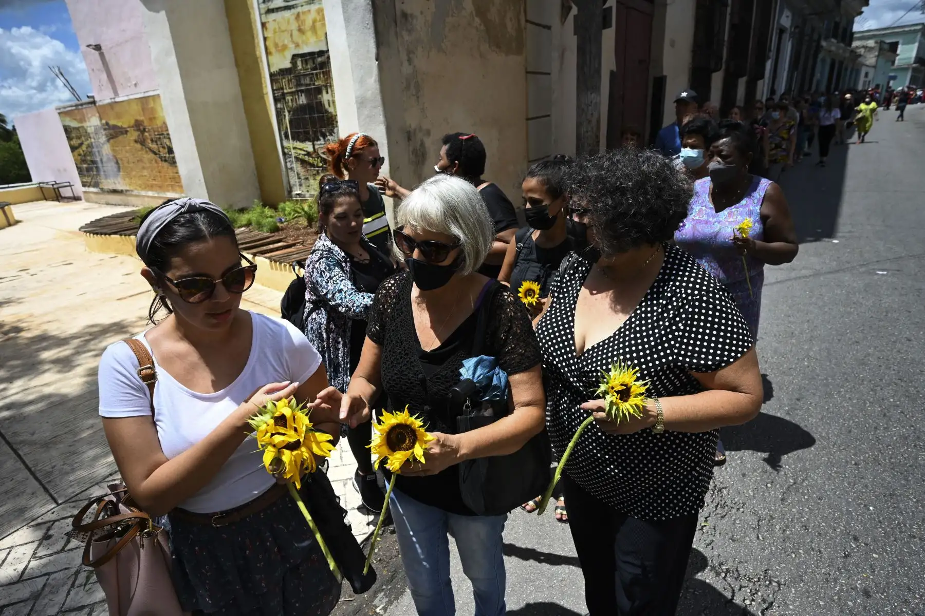 Personas con flores hacen fila para rendir homenaje a 14 bomberos que murieron en un gran incendio en un depósito de petróleo a principios de agosto, durante el funeral en el Museo de los Bomberos en Matanzas, Cuba.
Foto: AFP