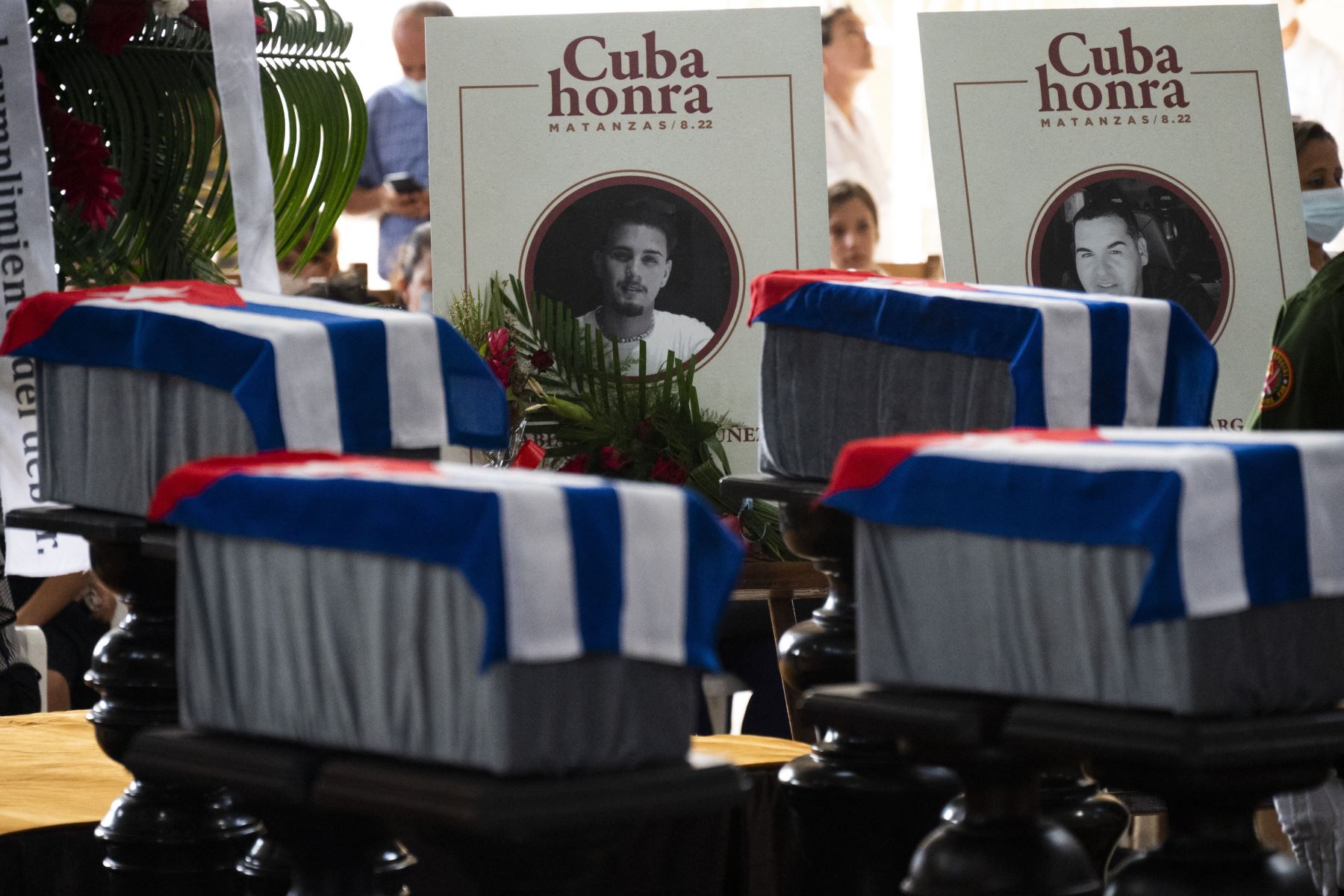 Vista de urnas y fotos de dos de los 14 bomberos que murieron en un gran incendio en un depósito de petróleo a principios de agosto durante su funeral en el Museo de los Bomberos en Matanzas, Cuba.
Foto: AFP