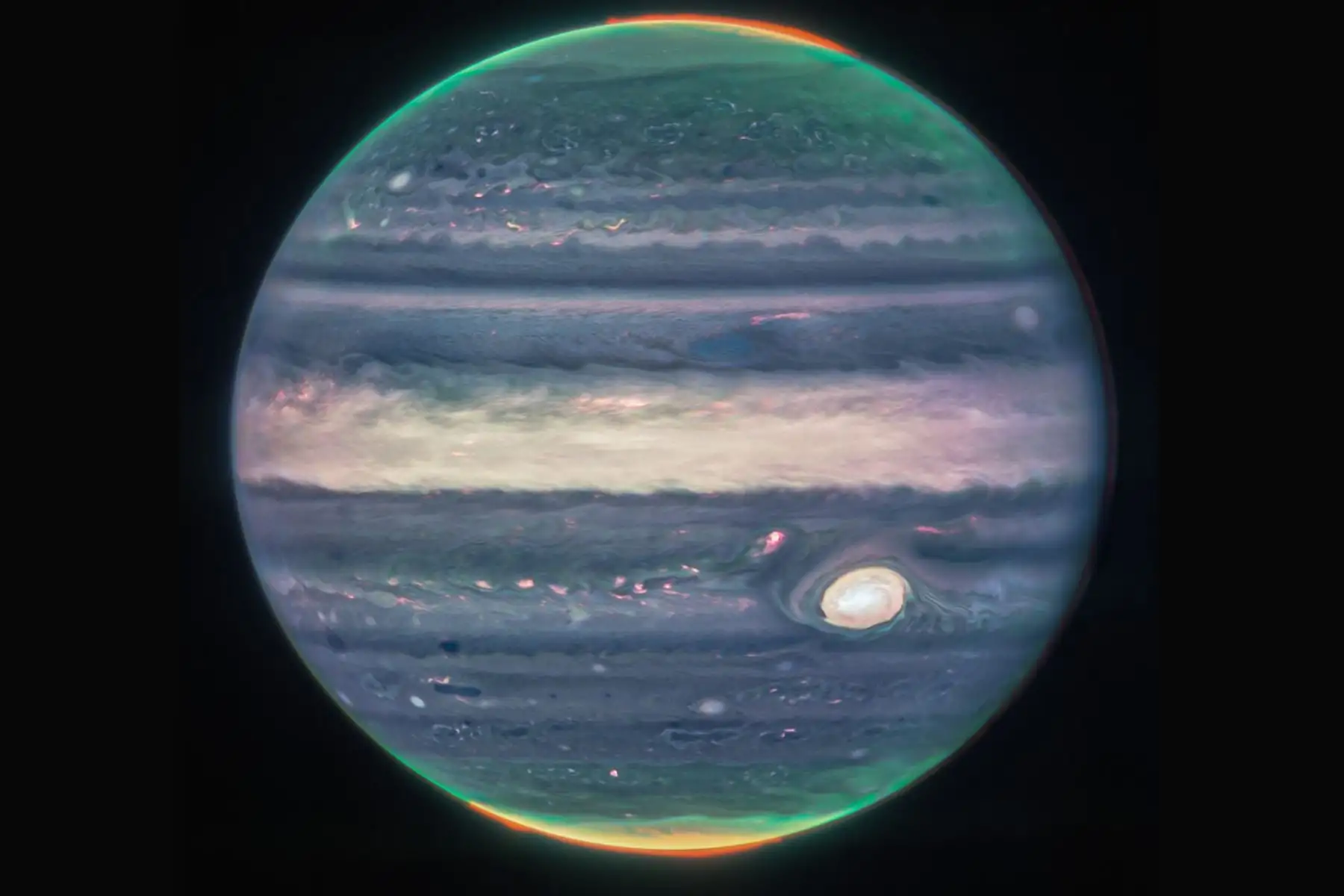 En la primera imagen, Júpiter domina el fondo negro del espacio. La imagen es una composición, y muestra a Júpiter en color realzado. La Gran Mancha Roja del planeta aparece aquí de color blanco.
Foto: Nasa webb