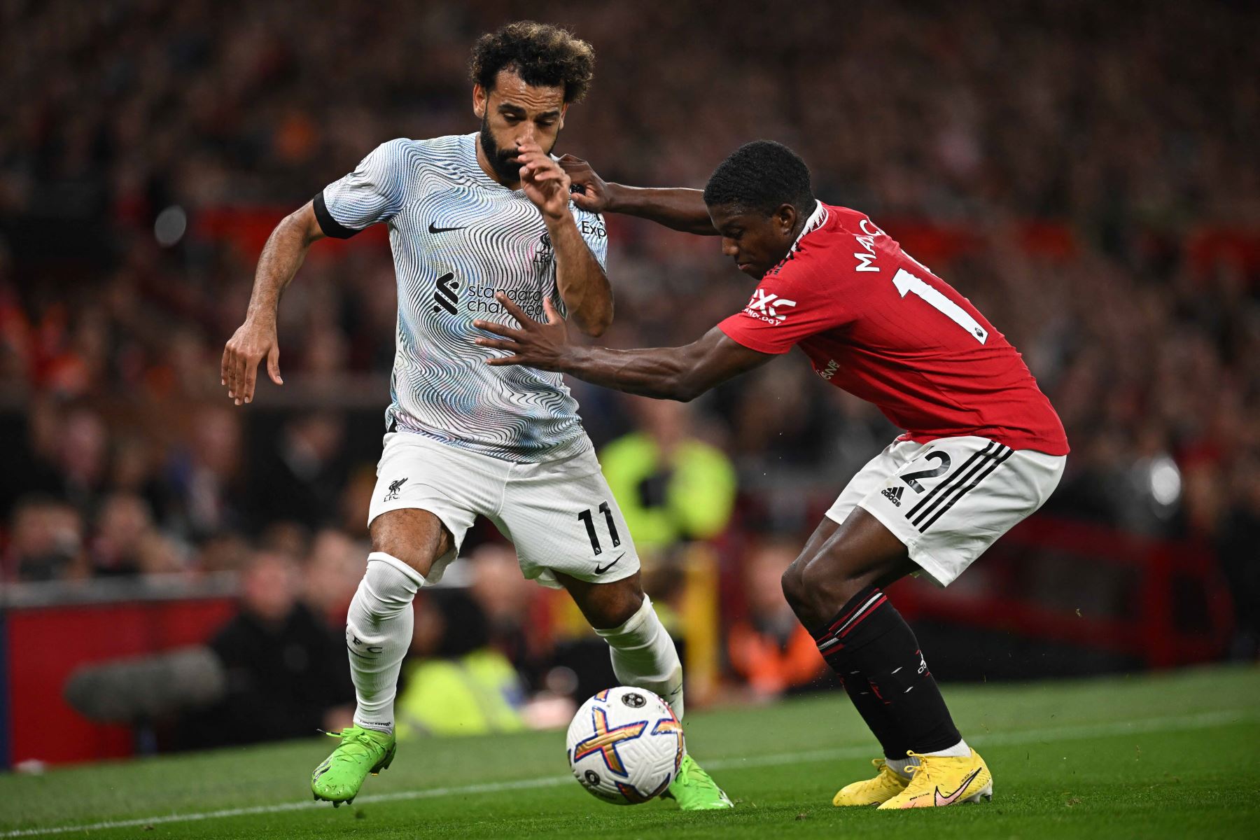 El delantero egipcio del Liverpool Mohamed Salah, compite con el defensor holandés del Manchester United Tyrell Malacia, durante el partido de fútbol de la Premier League inglesa entre el Manchester United y el Liverpool en Old Trafford en Manchester. Foto: AFP