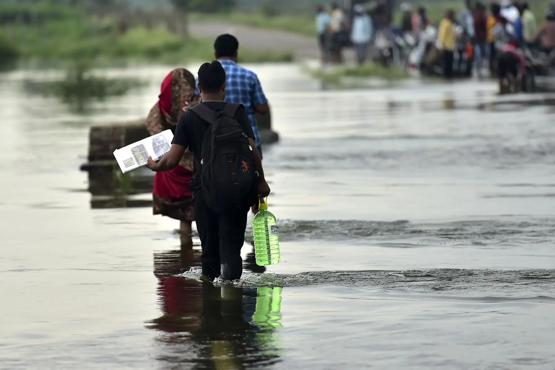 Los aldeanos cruzan un camino inundado causado por las inundaciones después de un aumento en los niveles de agua de los ríos Yamuna y Ganges luego de las lluvias monzónicas en el pueblo de Badara Sanuti cerca de Allahabad. Foto: AFP